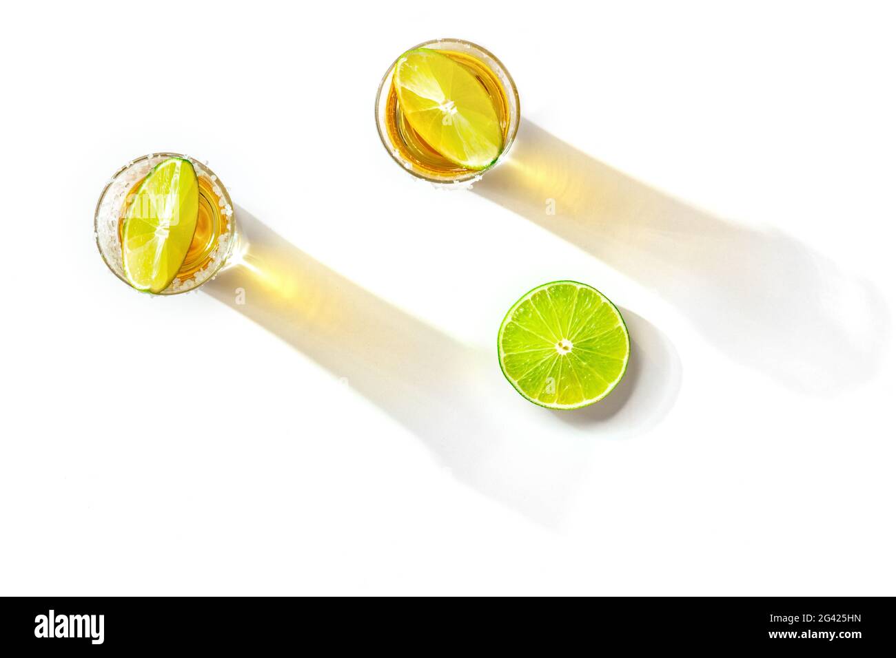 Tequila shots with salty rims and lime slices, overhead flat lay shot Stock Photo