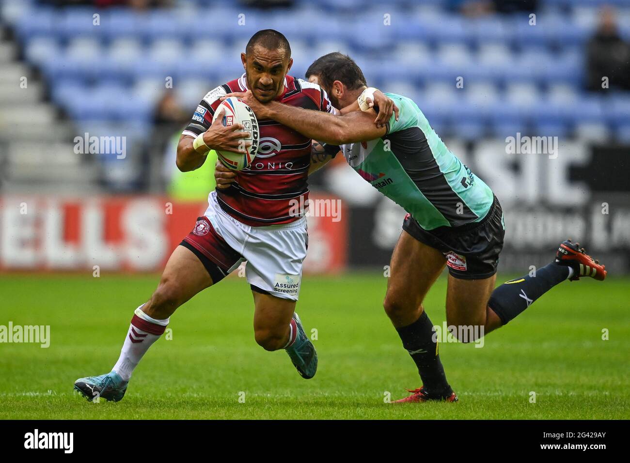 Thomas Leuluai (7) of Wigan Warriors is tackled by Kane Linnett (12) of Hull KR Stock Photo