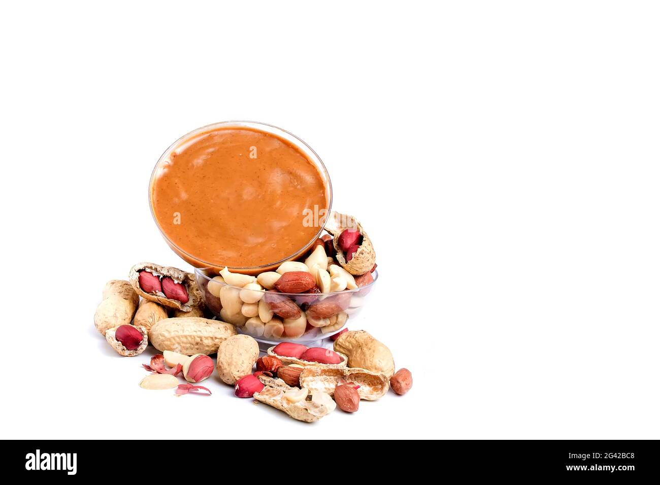 Peanut butter isolated and peanuts in the peel scattered on the white