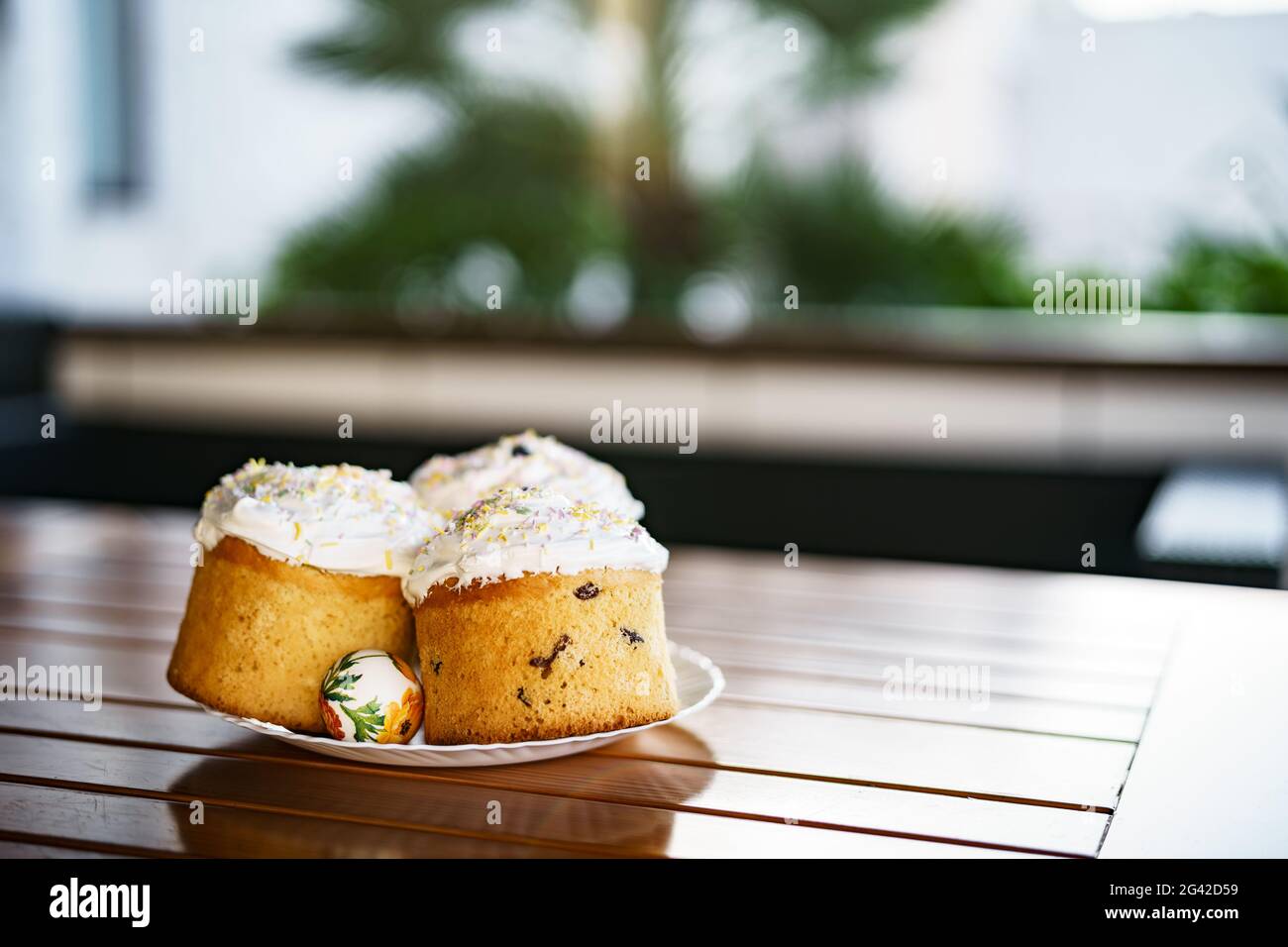 Plate with Easter cakes and decorated Easter eggs. Stock Photo