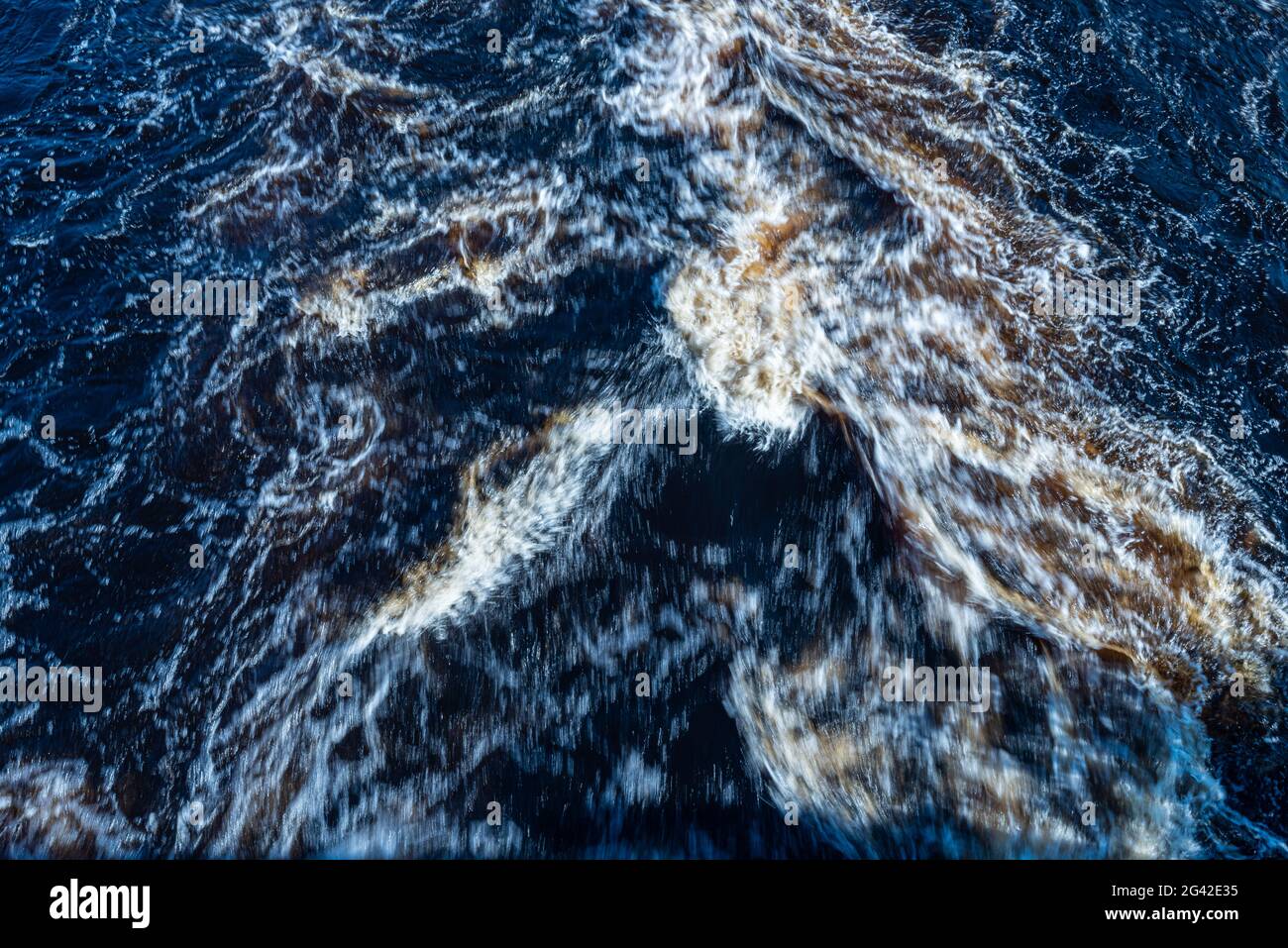Brown water rushing down a river Stock Photo - Alamy