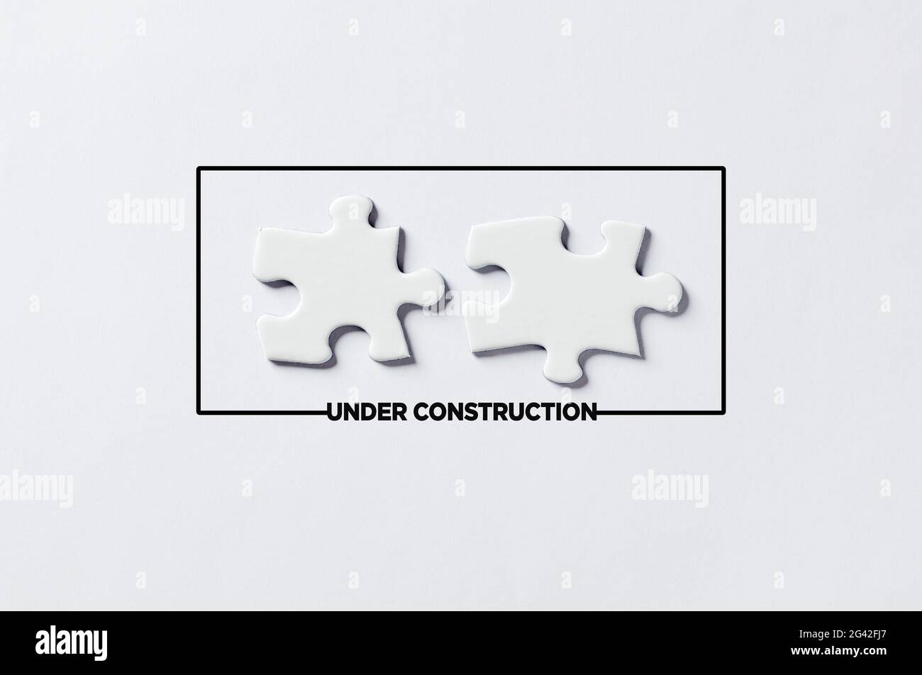 Under construction message with two separated puzzle pieces. Website construction or maintenance concept. Stock Photo