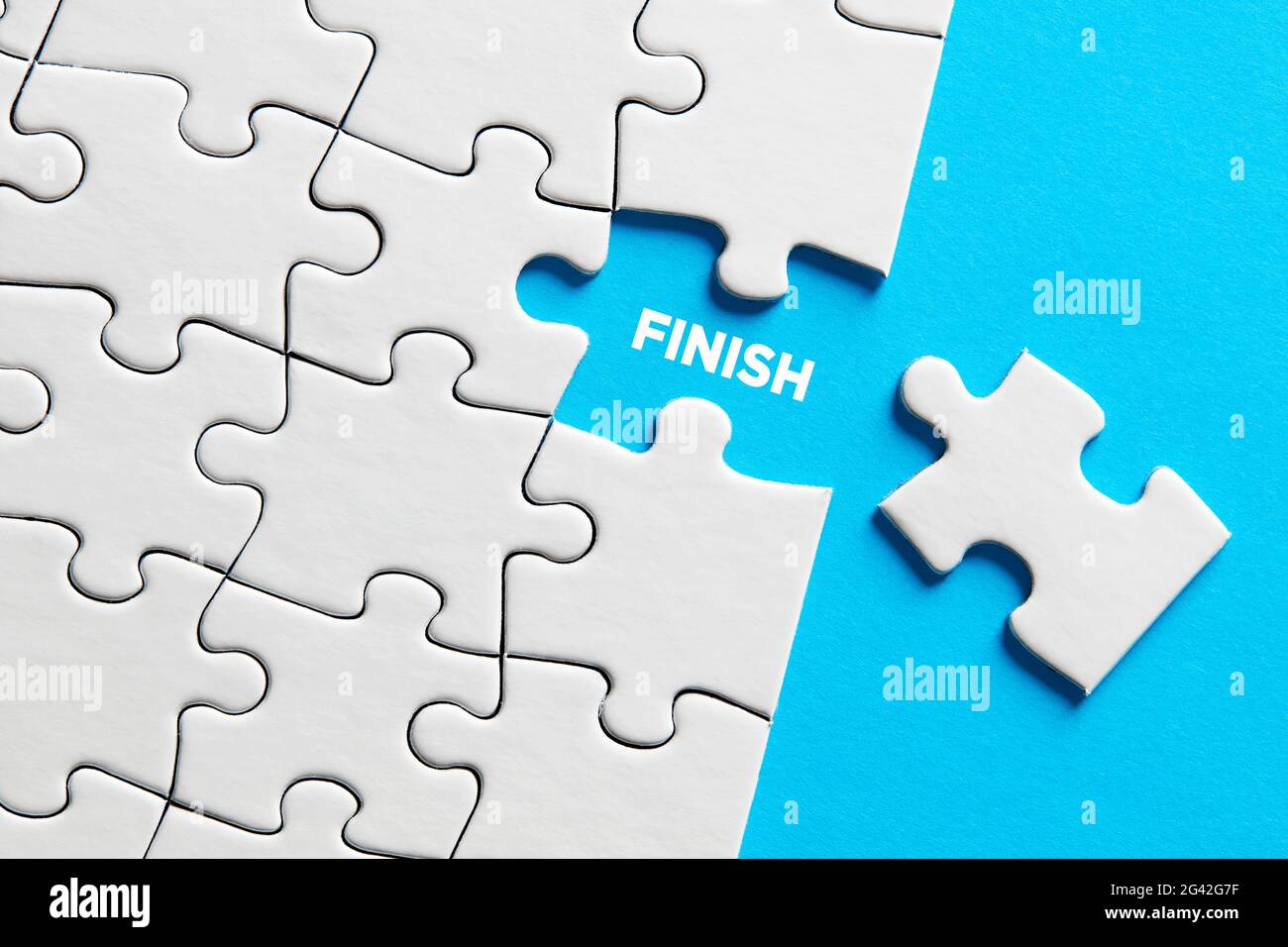 The word finish on missing puzzle piece. To finish or complete a task concept. Stock Photo