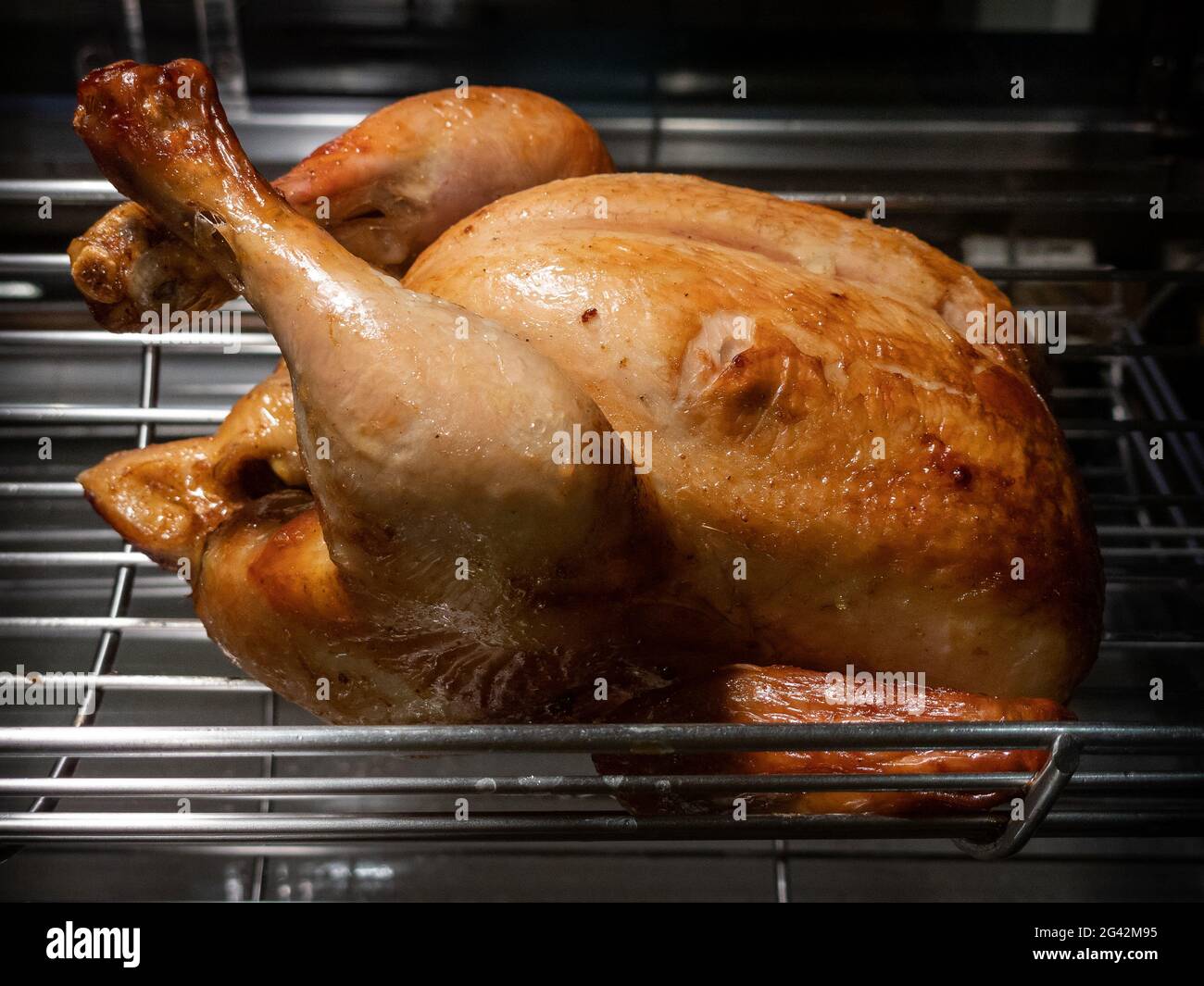 Rotating machine are grilled whole chicken. Roasted chickens in a row turning at industrial roaster. A barbecue roast skewer in a commercial oven roti Stock Photo