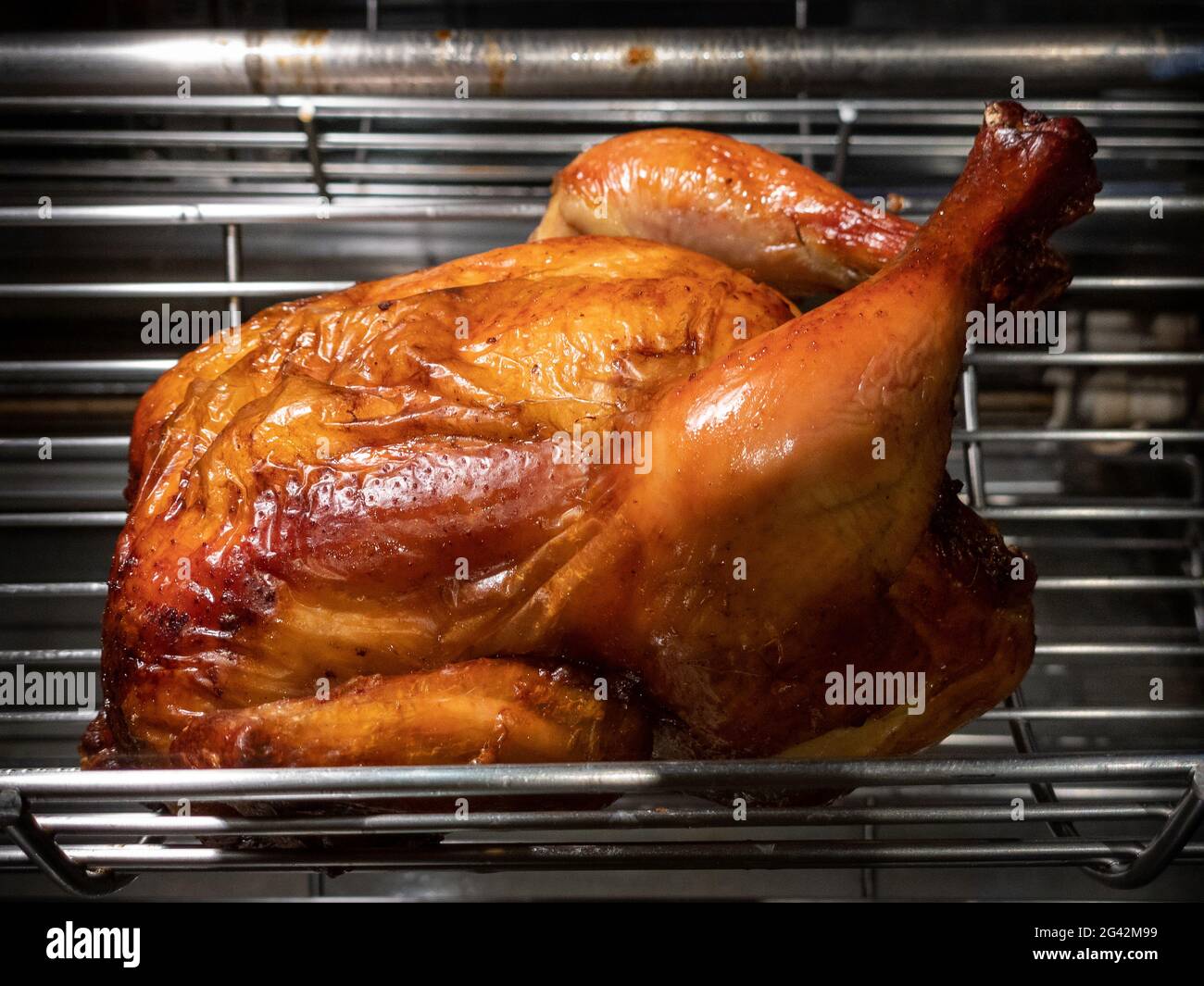 Rotating machine are grilled whole chicken. Roasted chickens in a row turning at industrial roaster. A barbecue roast skewer in a commercial oven roti Stock Photo