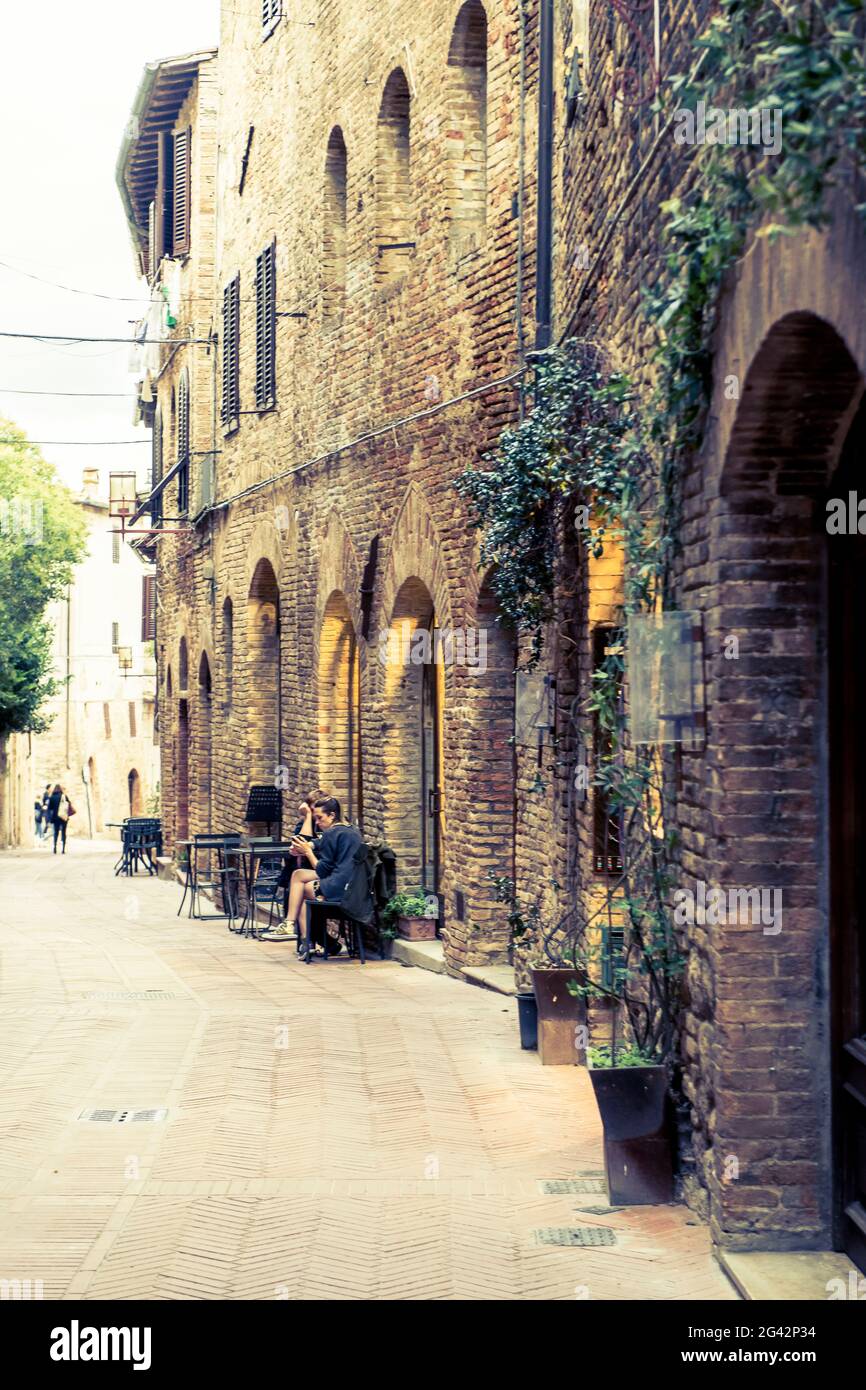 Sidewalk cafe in the alleys of San Gimignano, Province of Siena, Tuscany, Italy Stock Photo