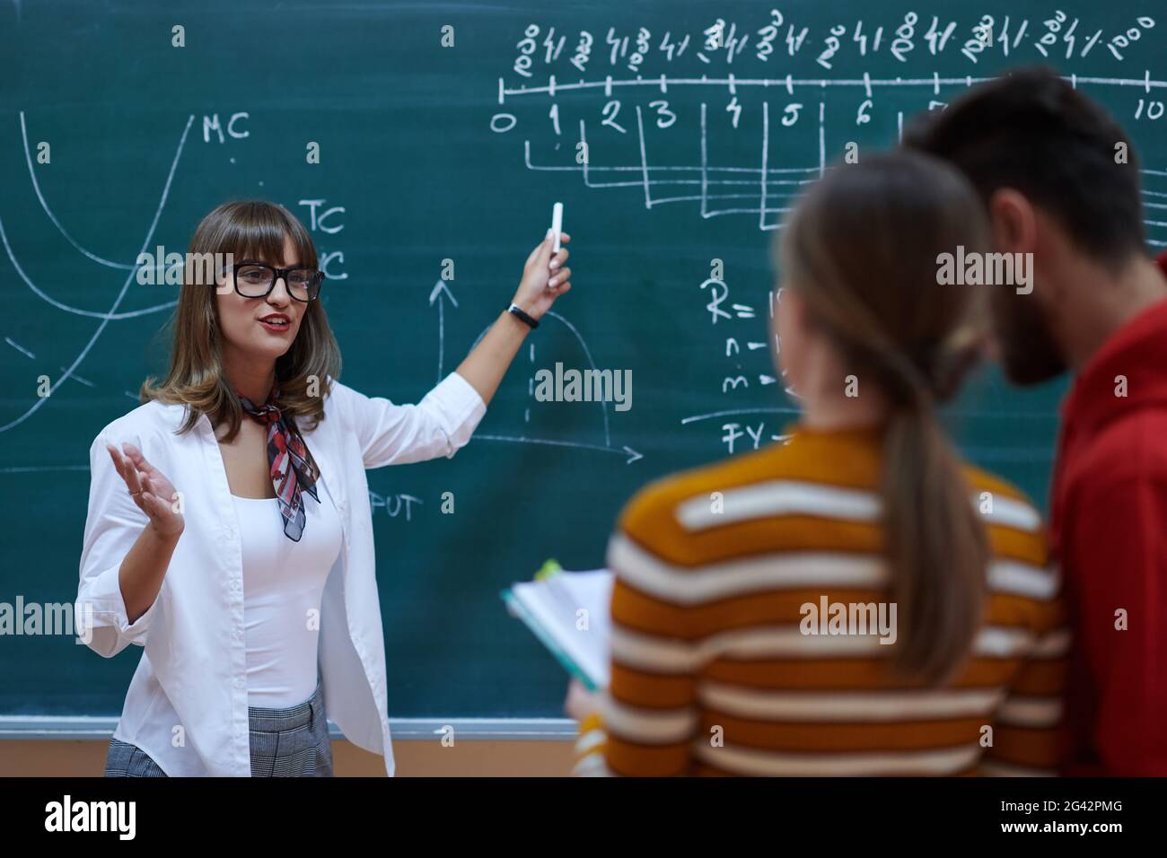 The professor explains the task on the board Stock Photo