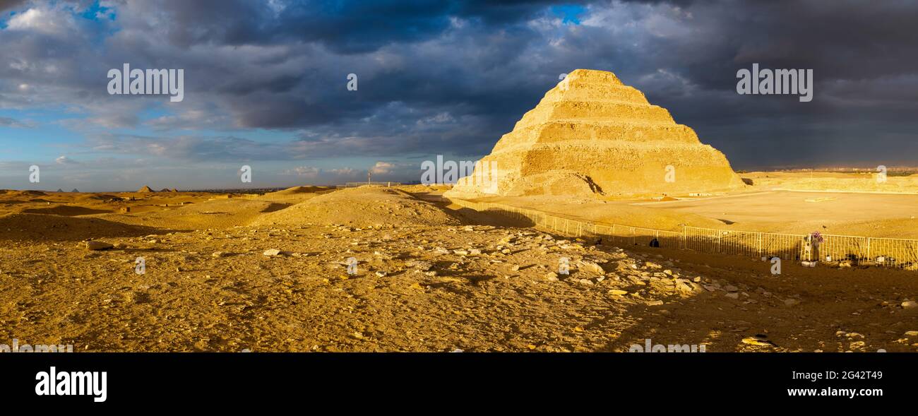 Stepped Pyramid of Djoser against storm clouds, Saqqara, Al Badrashin, Giza Governate, Egypt Stock Photo