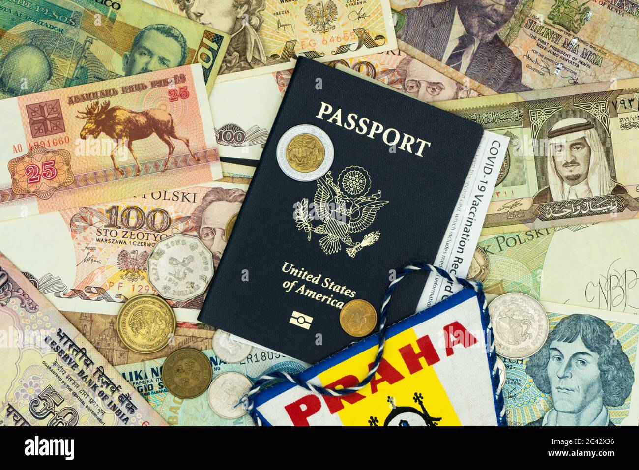 Lake Elsinore, CA, USA June 19, 2021: Right angled passport with COVID-19 vaccination card on top of mixed foreign money. Stock Photo