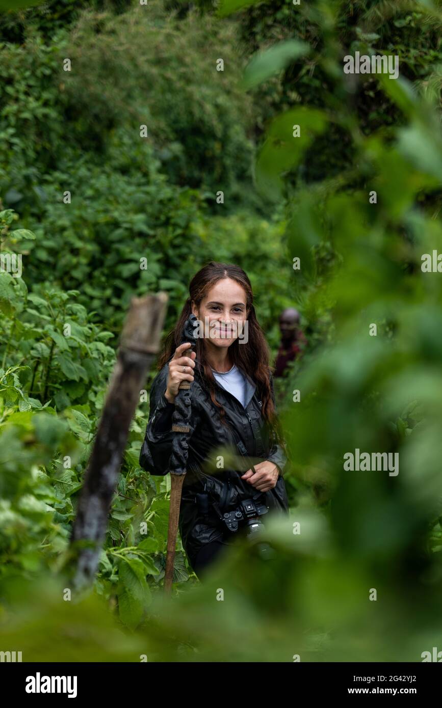 Young woman with hiking stick during a trekking excursion to the Sabyinyo group of gorillas, Volcanoes National Park, Northern Province, Rwanda, Afric Stock Photo