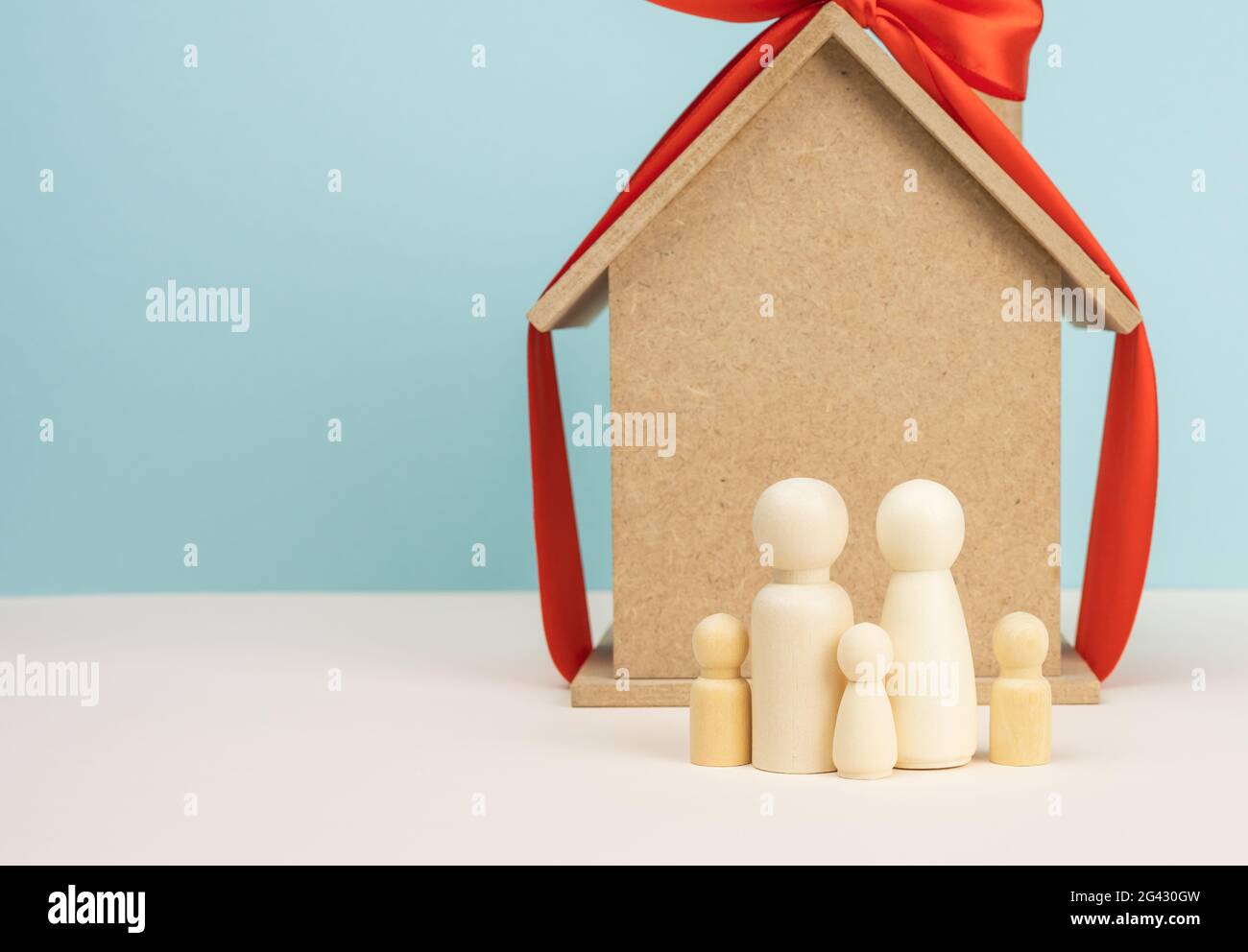 Wooden house and miniature family figures, mortgage and loan concept Stock Photo