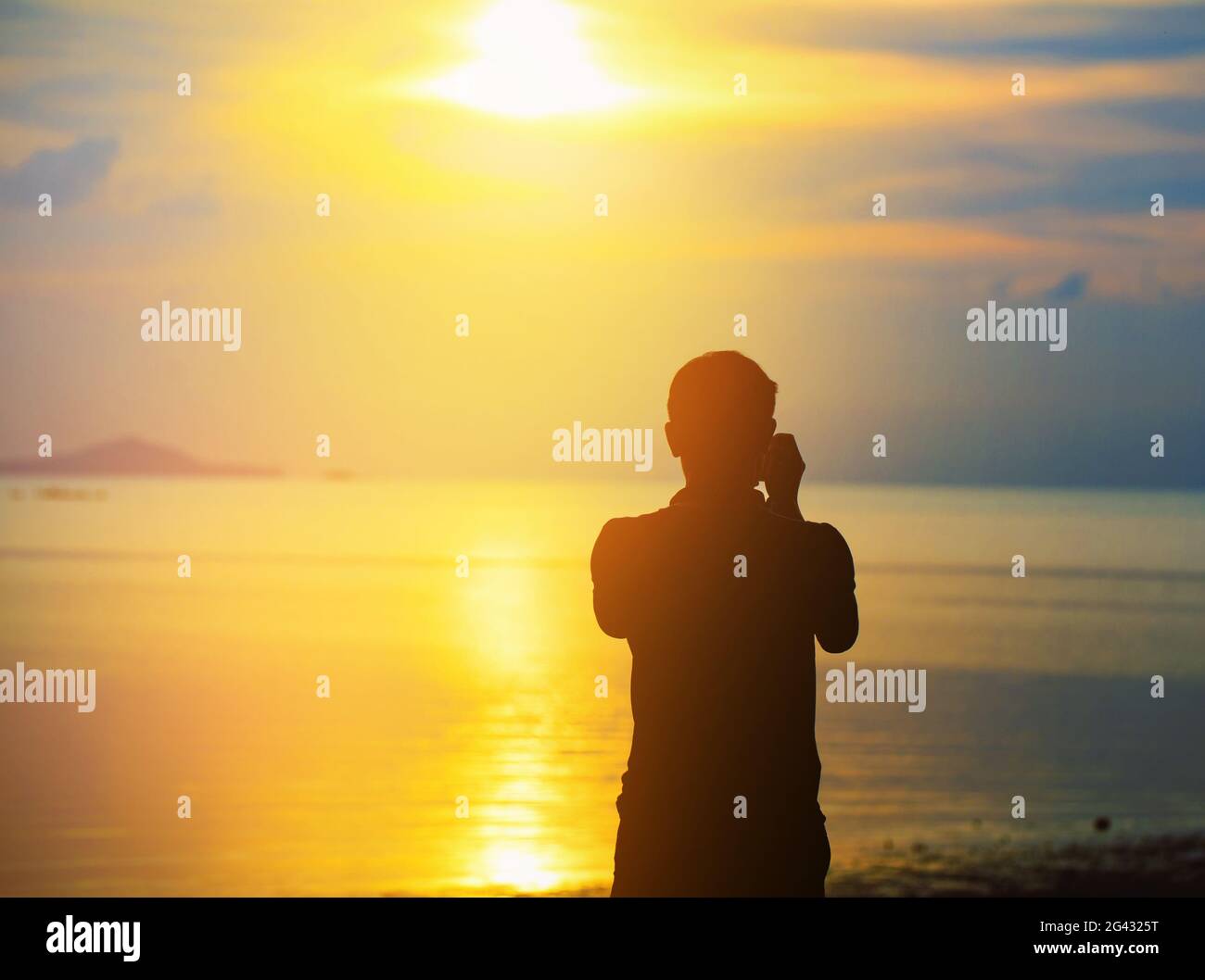 Silhouette Man taking photos of sunset with camera Stock Photo - Alamy