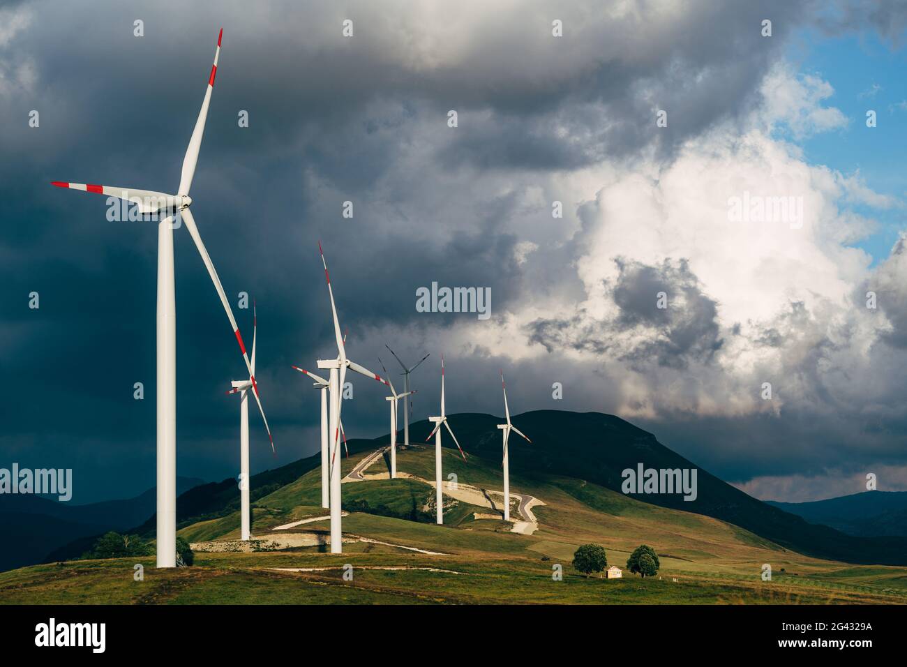 Huge high wind turbines on the hill, against the backdrop of an epic sky. Wind power plant in northern Montenegro. Stock Photo