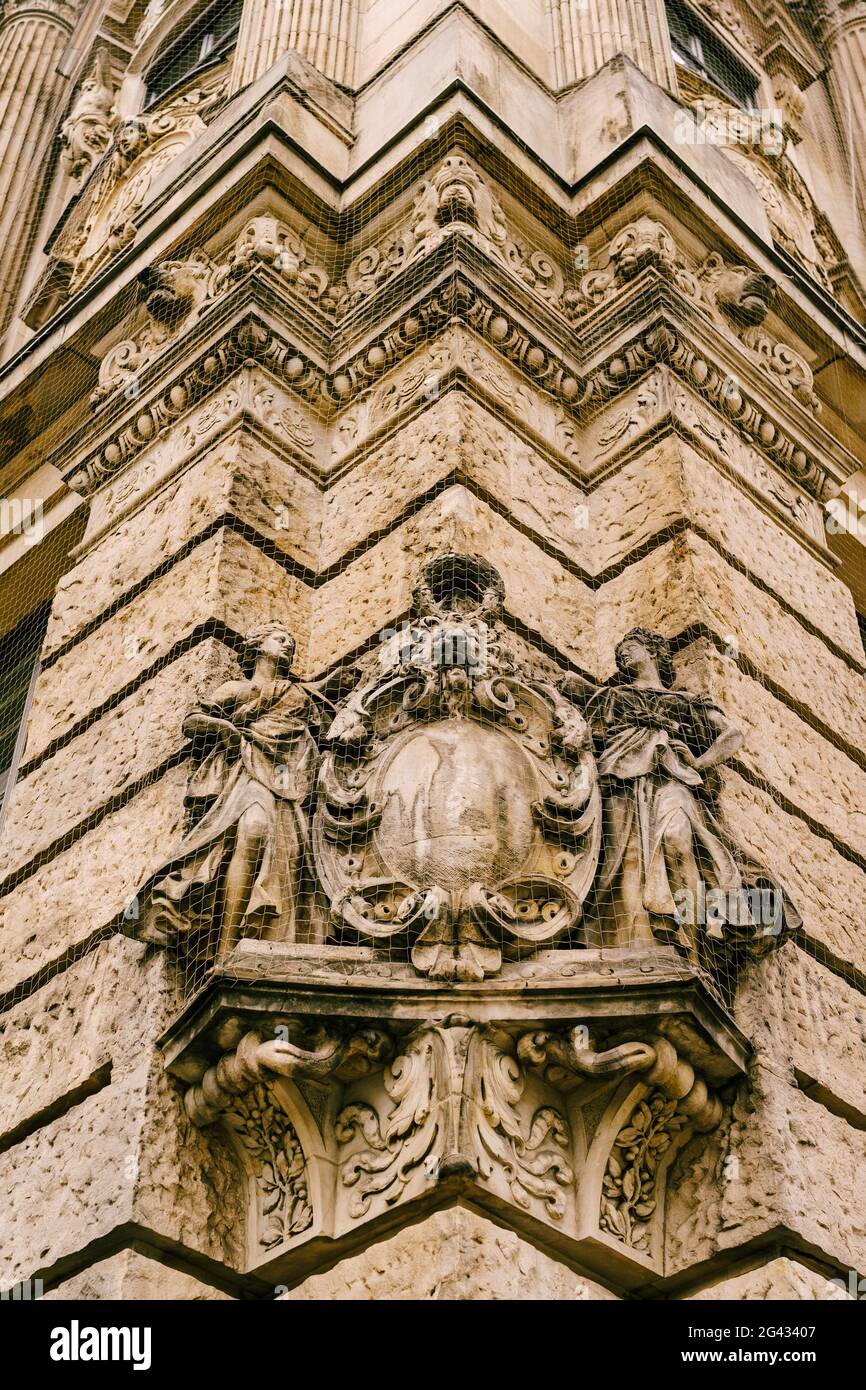 Gothic art in the form of high relief with figures of women and a lion's face on the wall of an ancient building Stock Photo