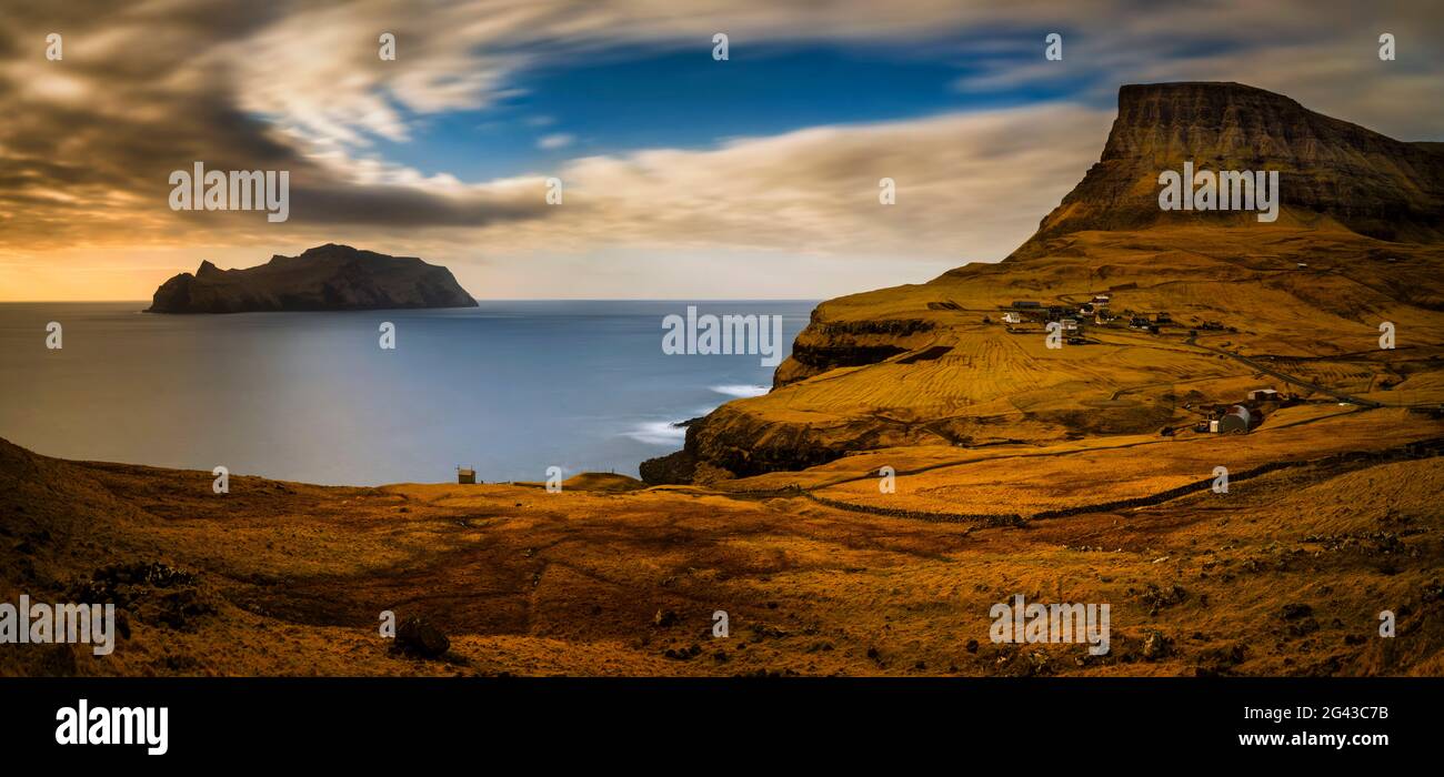 Landscape with coastal cliffs, Mykines island and Gasaldur village at sunset, Faroe Islands, Denmark Stock Photo
