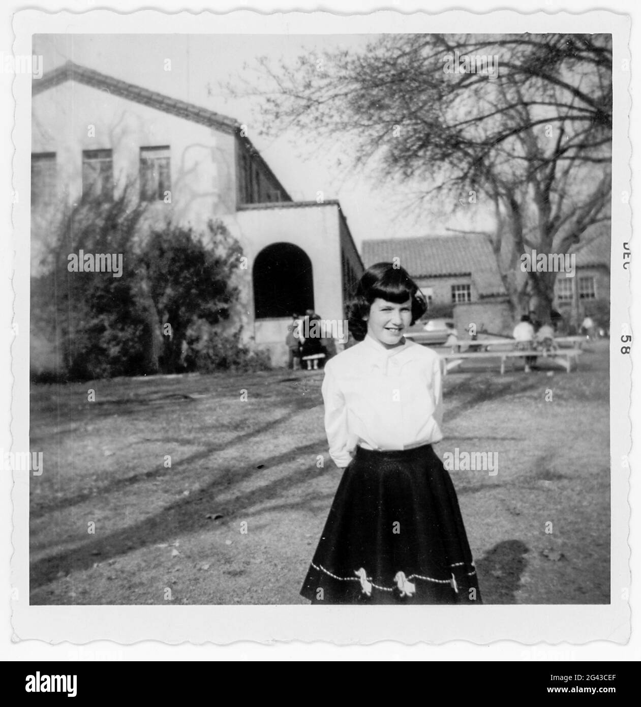Vintage 1959 Black and White Photo of Schoolgirl in Front of her Grade School, USA Stock Photo