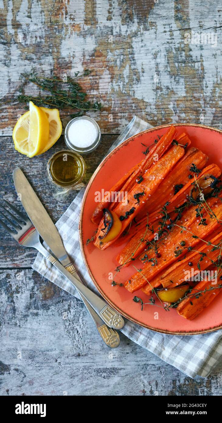 Baked carrots in strips with herbs and spices. Vegan diet. Vegan lunch recipe idea. Stock Photo