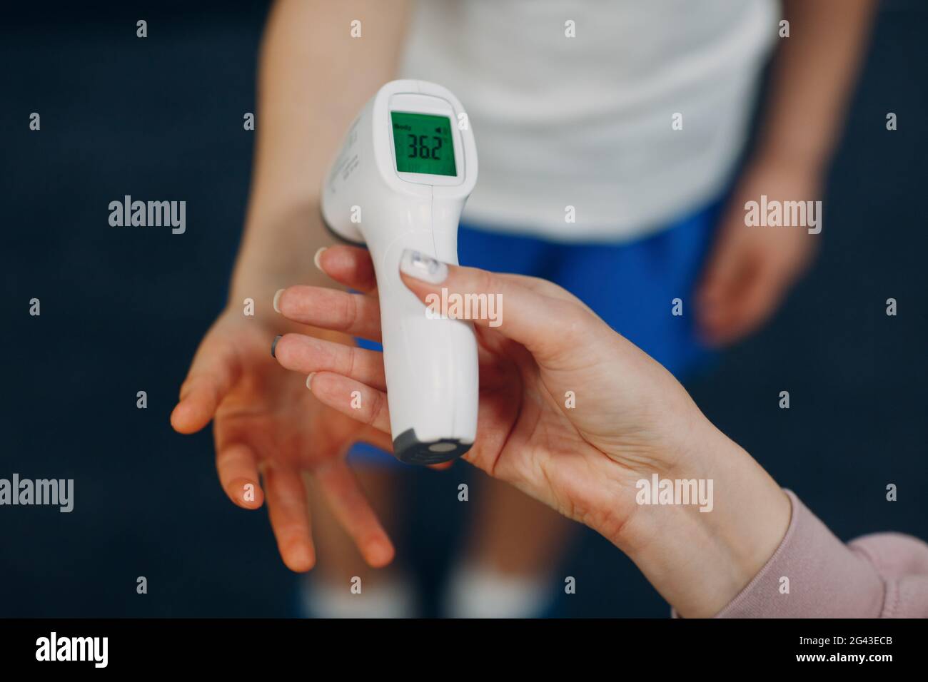 Child temperature measurement by laser thermometer at kindergarten