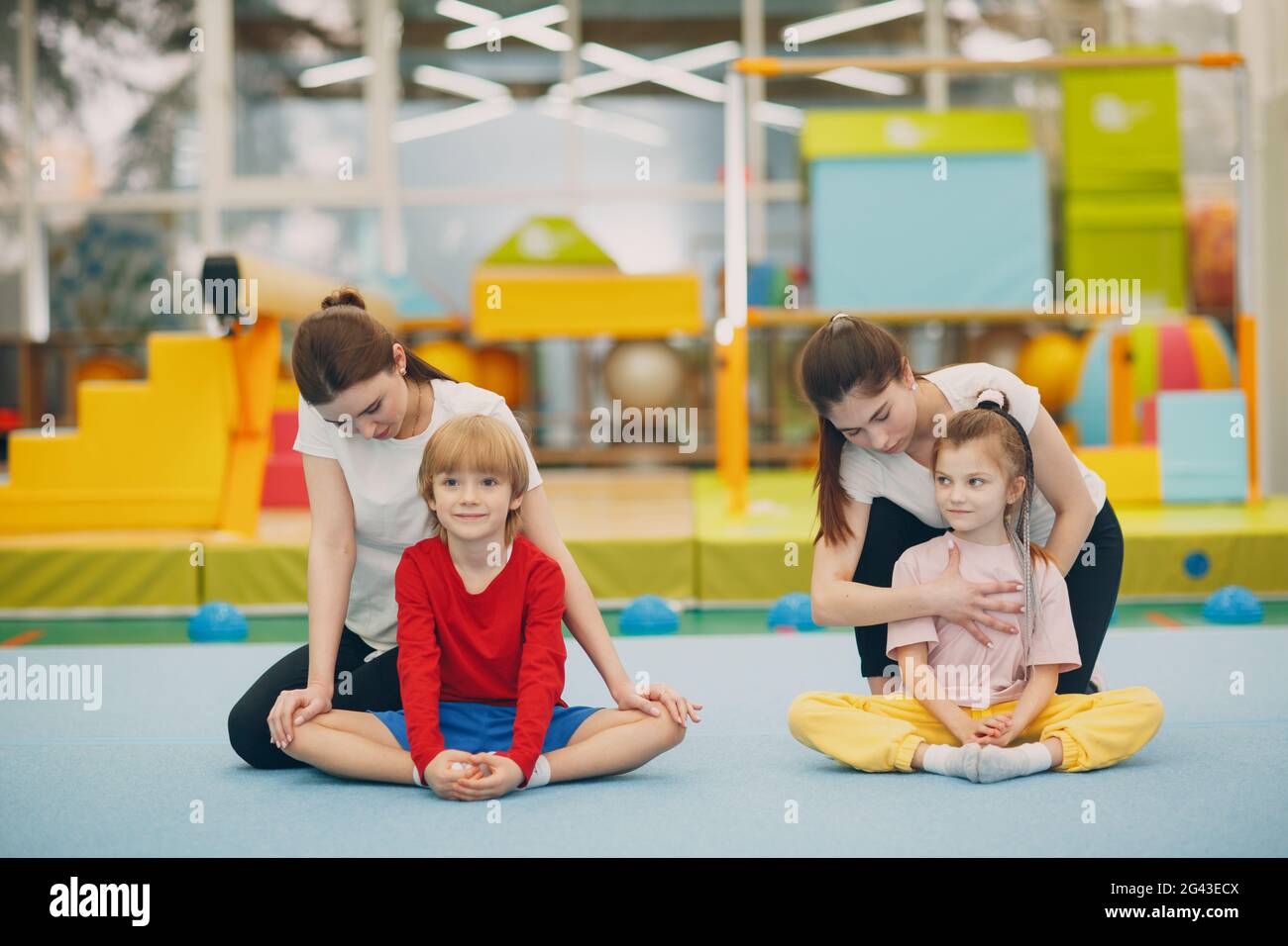 Kids doing stretching exercises in gym at kindergarten or elementary school. Children sport and fitness concept. Stock Photo