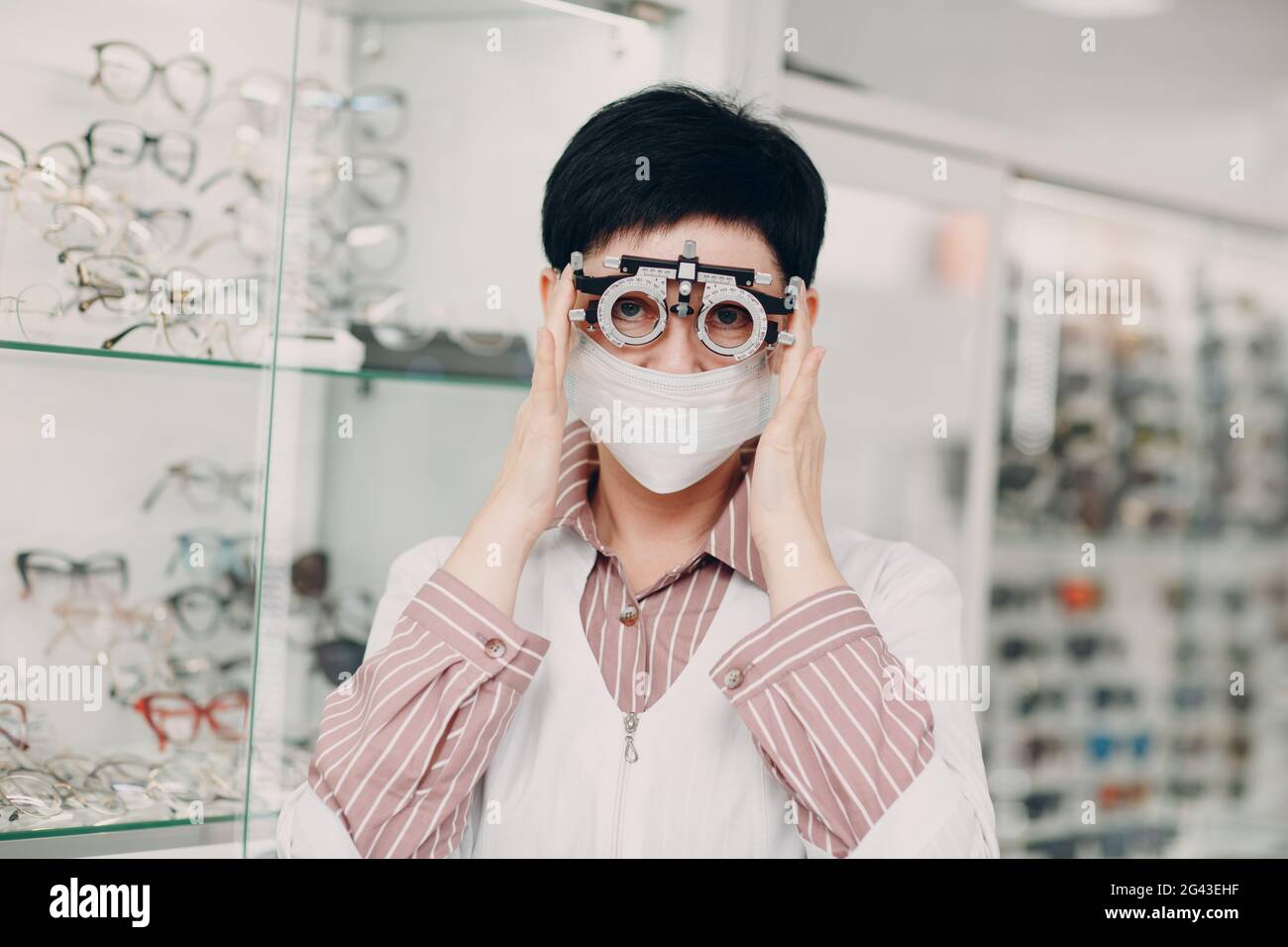 Portrait of an optometrist ophthalmologist middle aged woman wearing protective medical face mask Stock Photo
