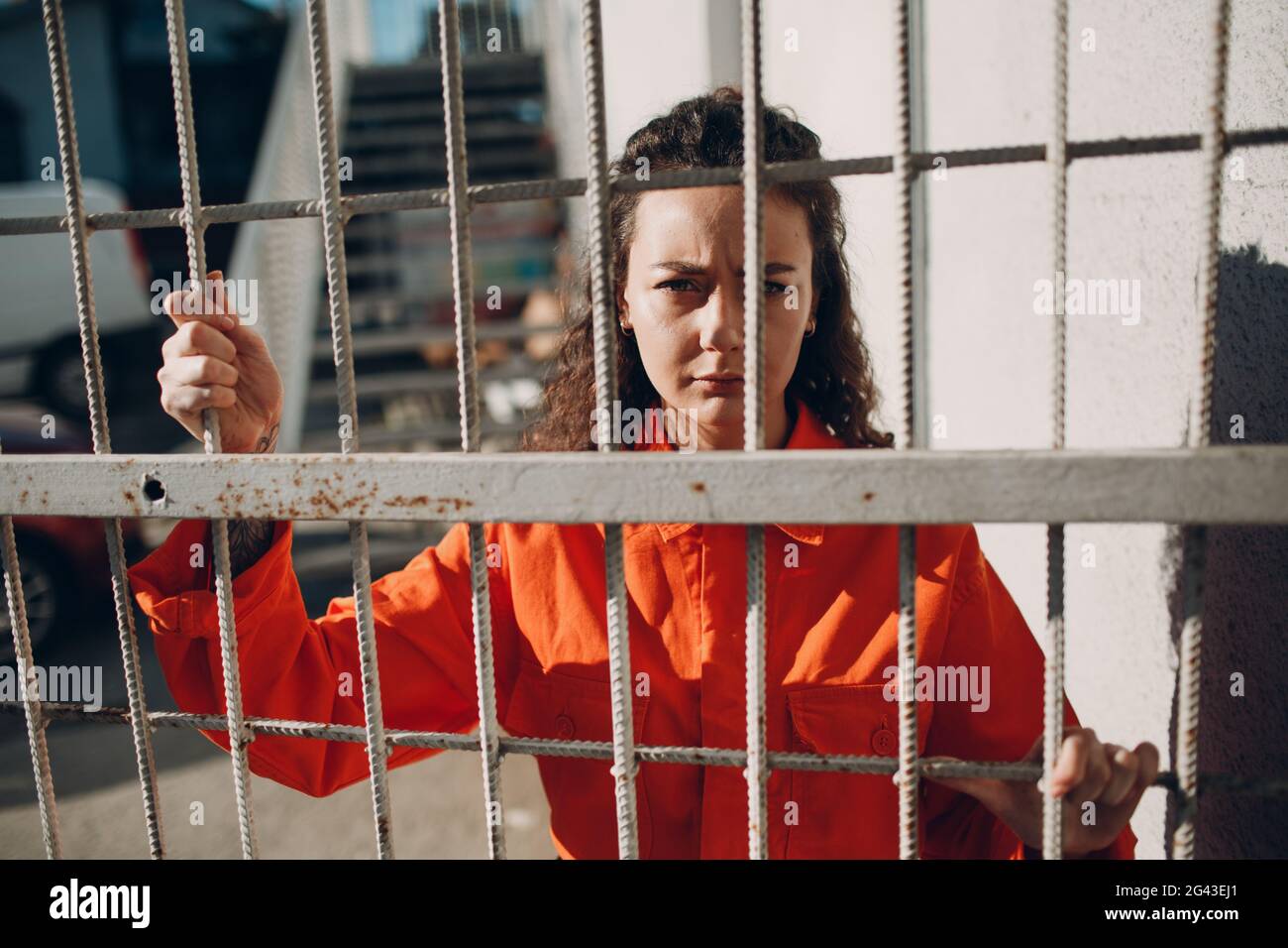 Young Woman In Orange Suit Behind Jail Bars Female In Colorful Young Woman In Orange Suit Behind Jail Bars Female In Colorful