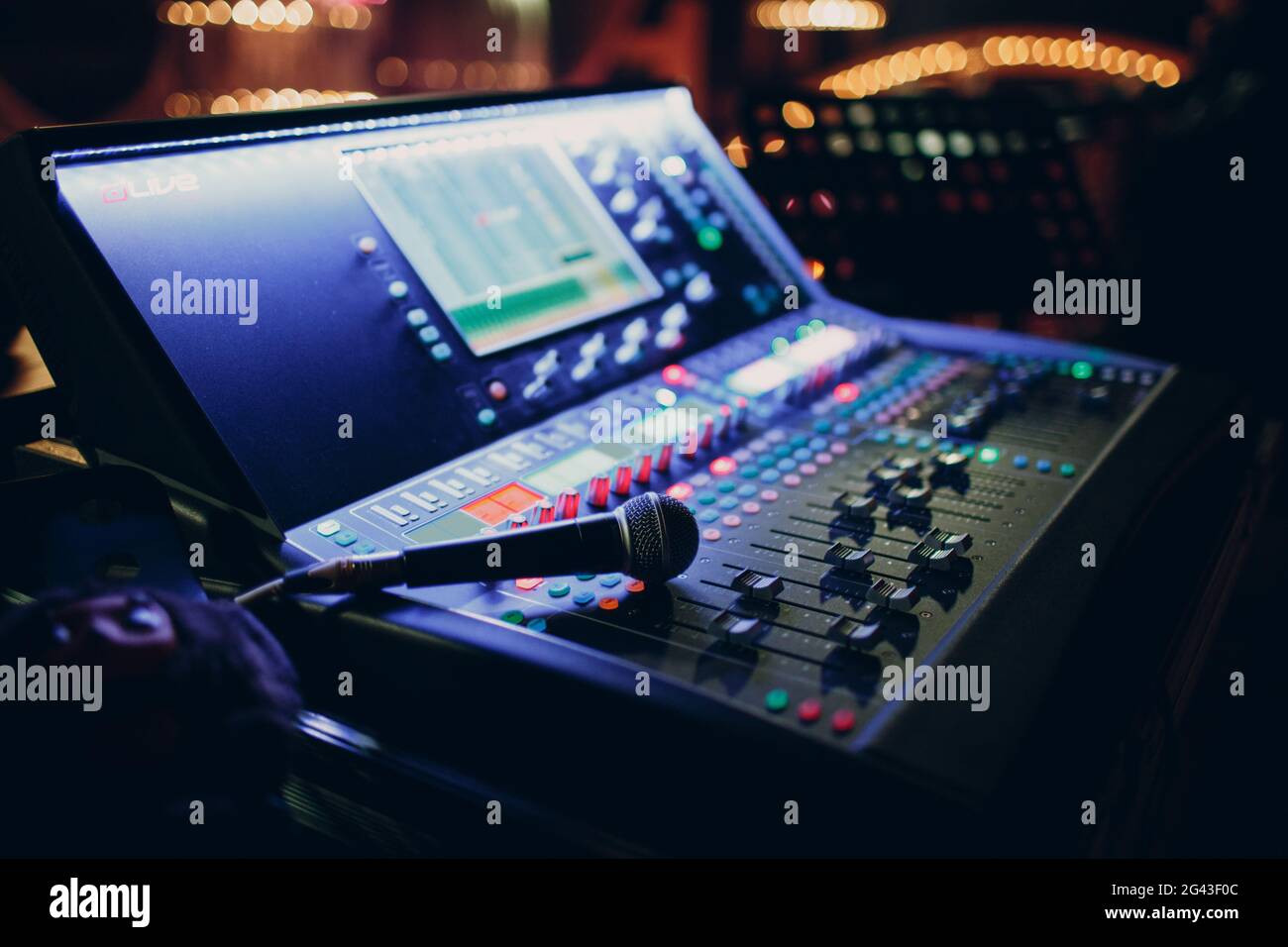 Mixing console and microphone, hand equalizing audio sound channels in night club Stock Photo