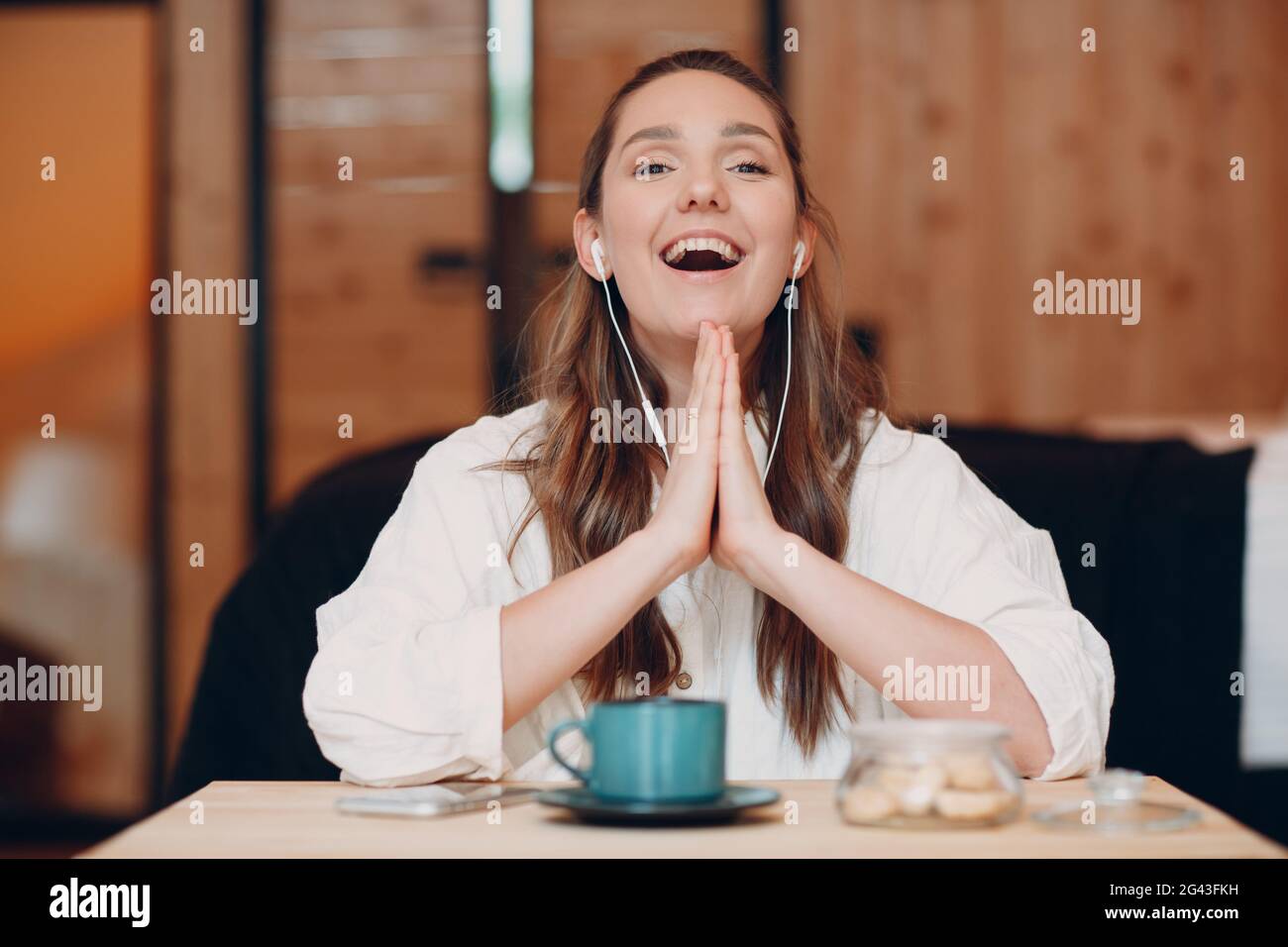 Screen app view of smiling young female sit at table with laptop and talking on video call with friend or co worker, happy girl Stock Photo