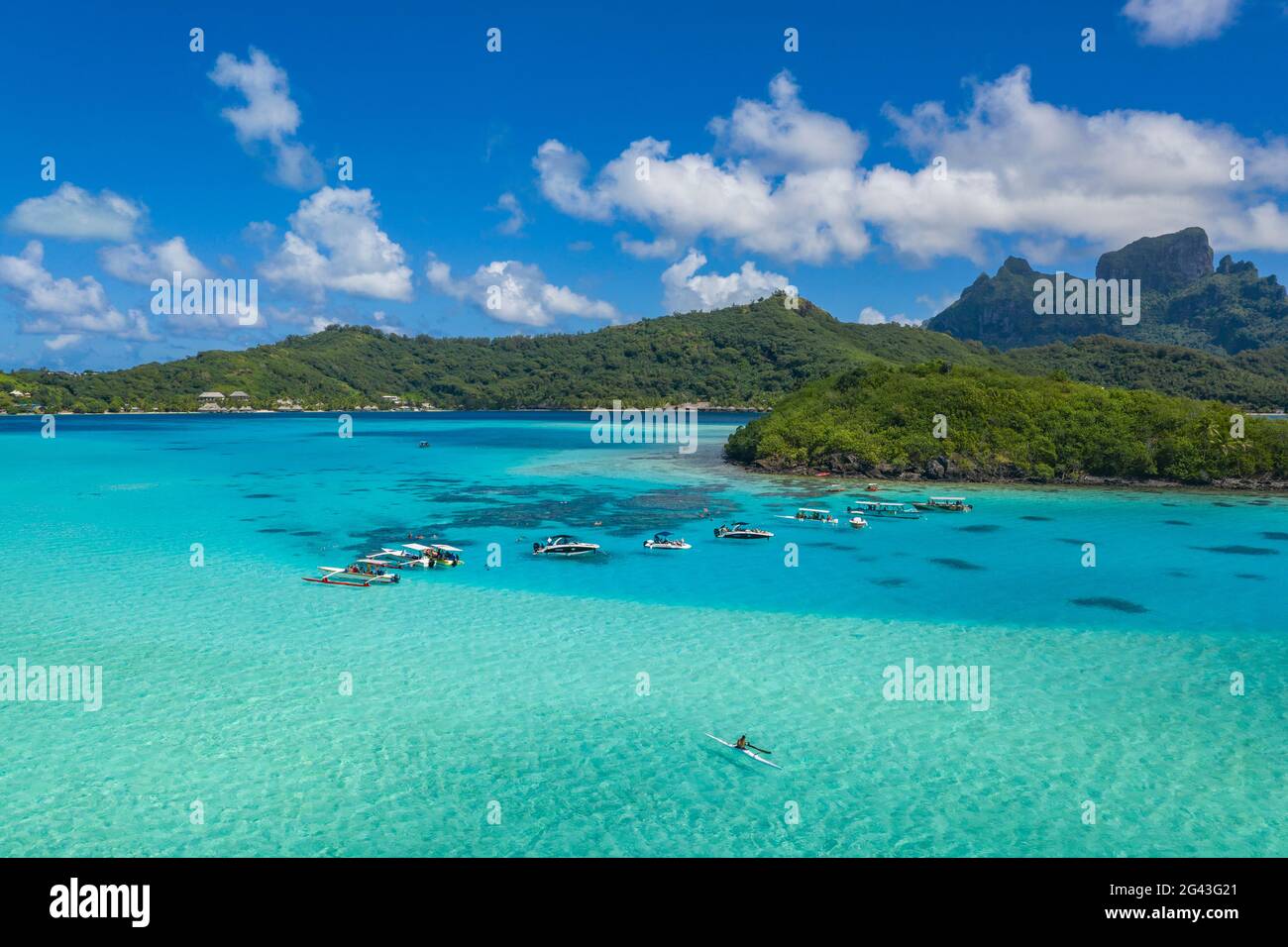 Aerial view of outrigger canoes and excursion boats in the Bora Bora Lagoon, Bora Bora, Leeward Islands, French Polynesia, South Pacific Stock Photo