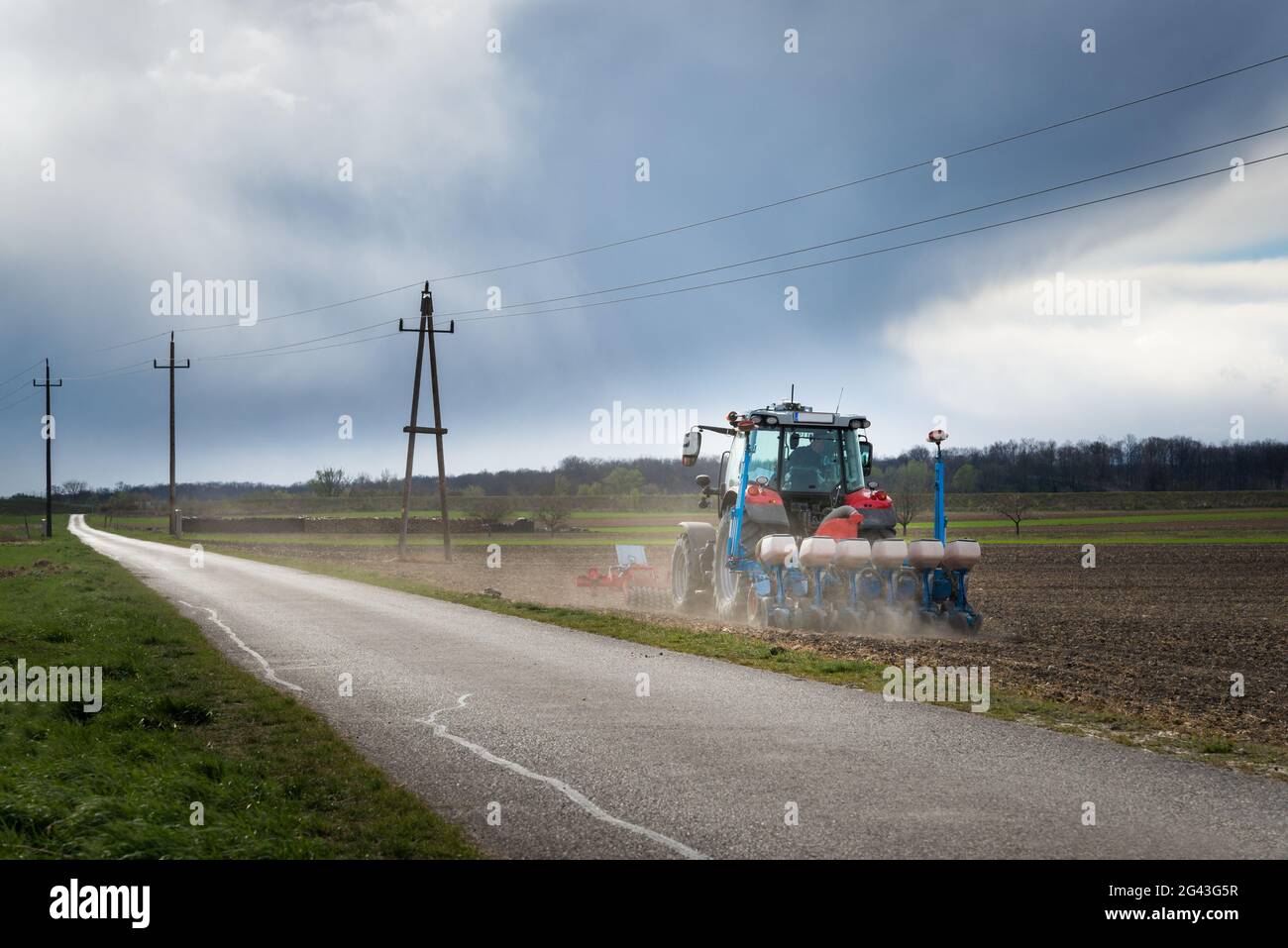 Tractor on a field seeding crop Stock Photo