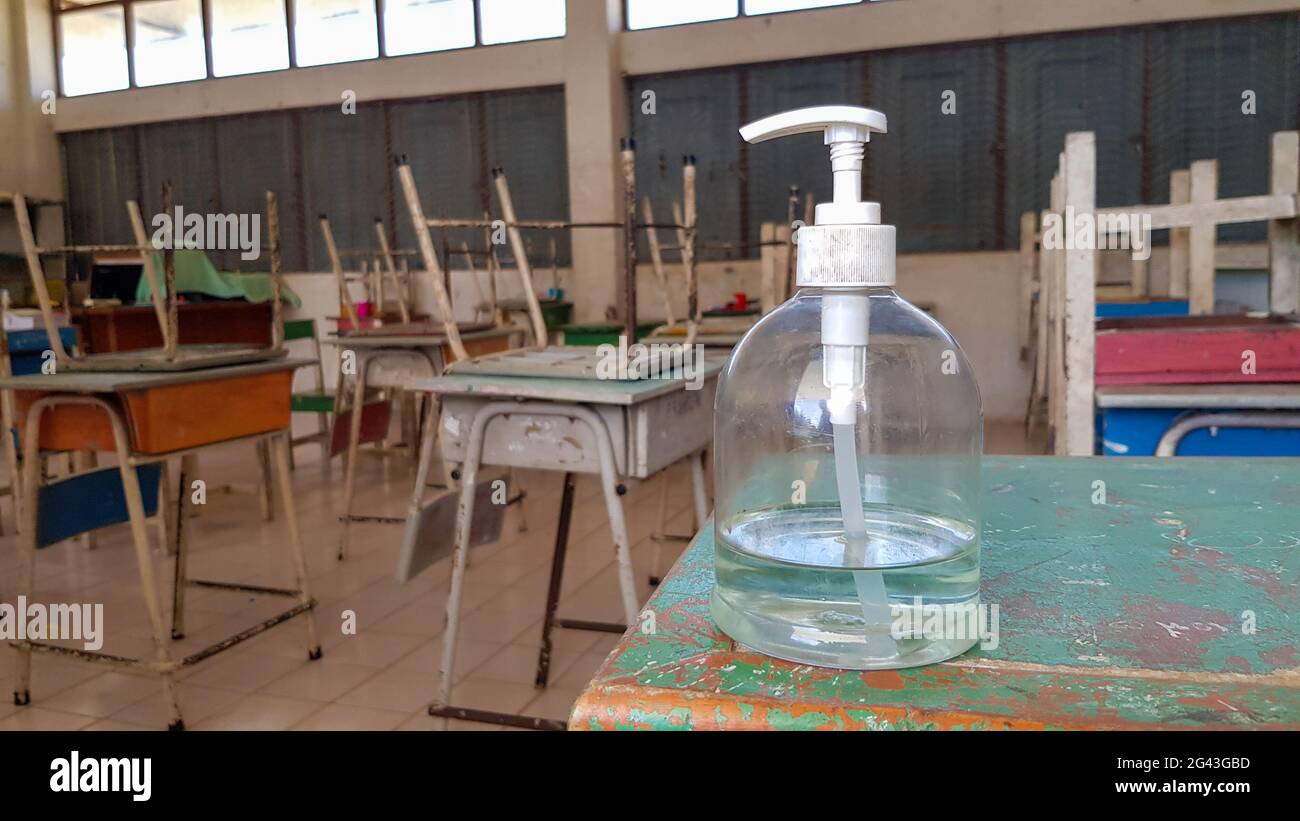 Alcohol gel is placed in a bottle in front of the classroom for students to wash their hands before entering the room. Stock Photo