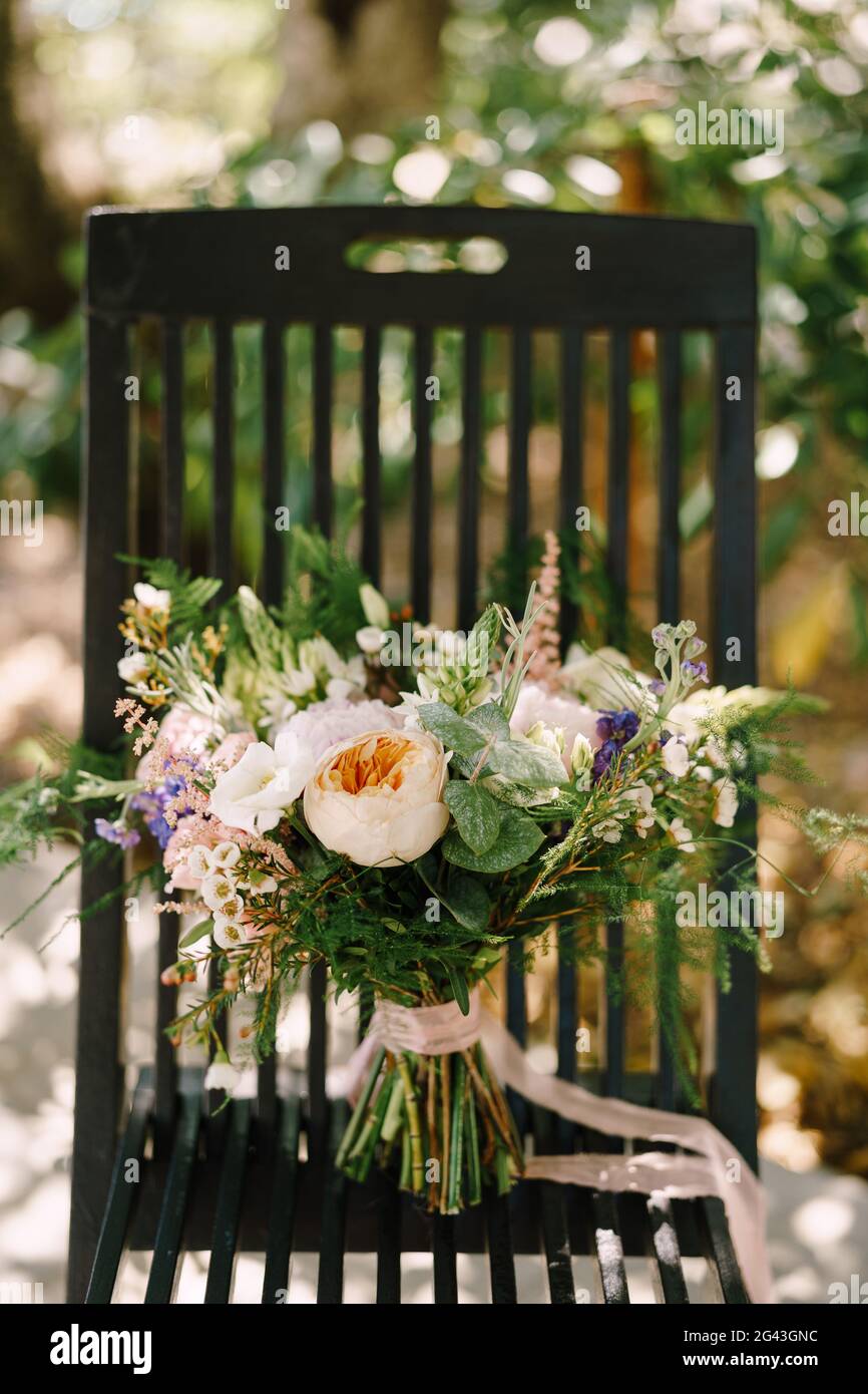Bridal bouquet of cream roses, pink peonies, eustoma, waxflower, astilbe, limonium, branches of eucalypt tree, mattiola, asparag Stock Photo