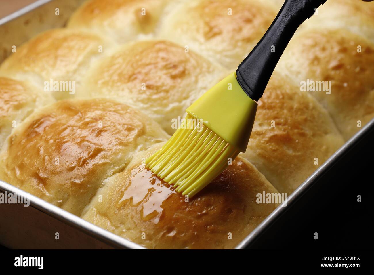 Brushing butter on rolls Stock Photo Alamy