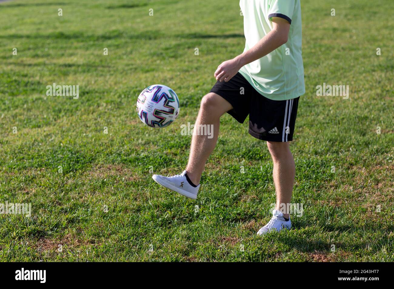 Football freestyle. Young man practices with soccer ball. Player