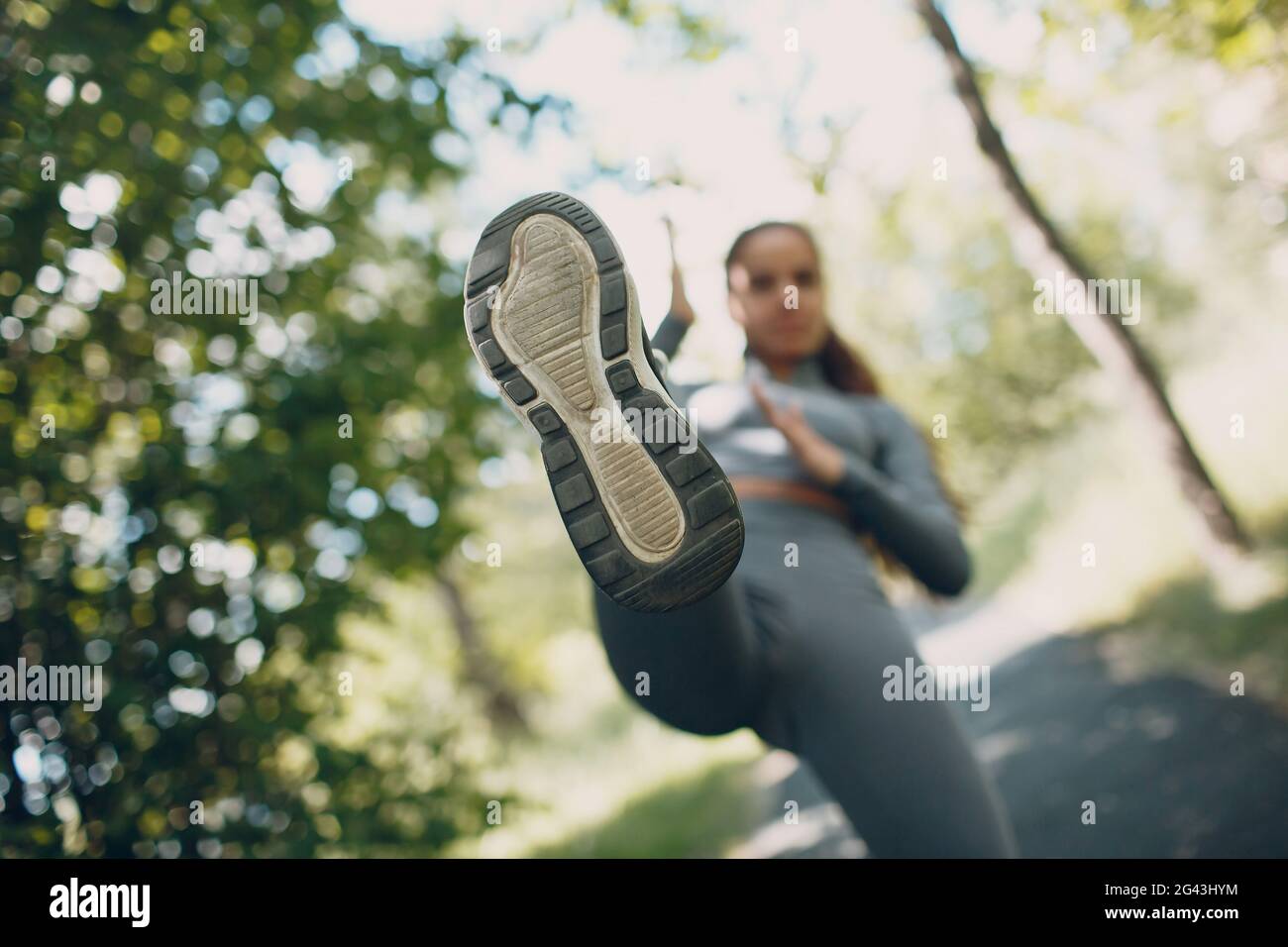 Girl kicking with her leg in camera, sole close up. Foreground focus. Stock Photo