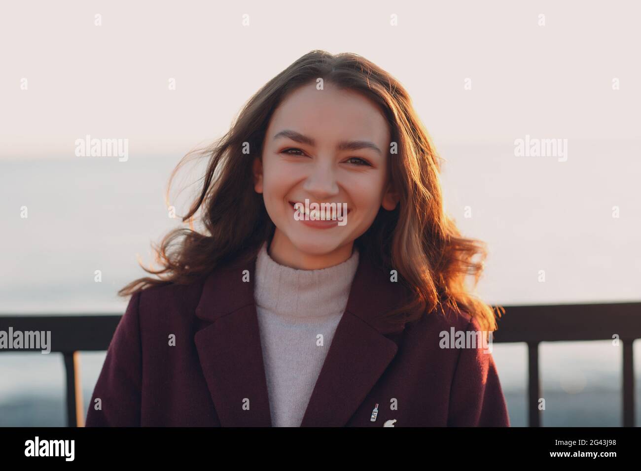 Young smiling brunette woman in coat outdoors portrait Stock Photo - Alamy