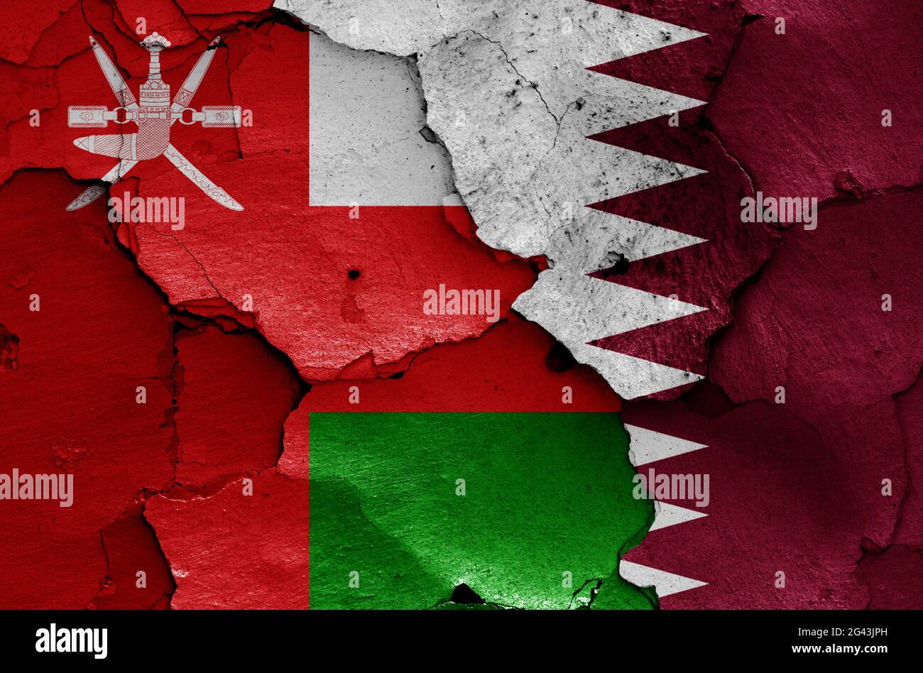 Flags of Oman and Qatar painted on cracked wall Stock Photo