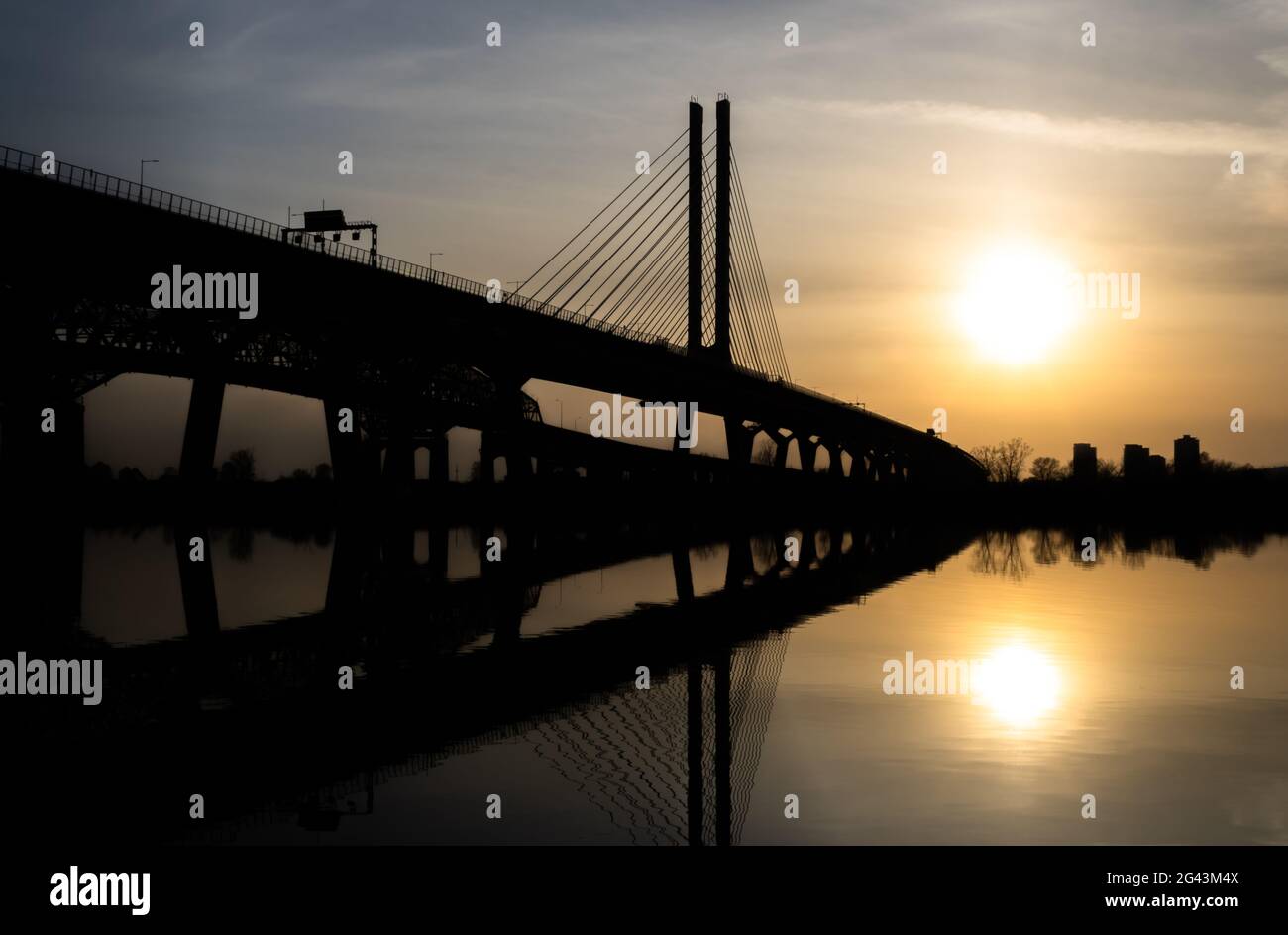 A beautiful sunset with the silhouette of Champlain bridge heading towards Montreal from Brossard. Stock Photo