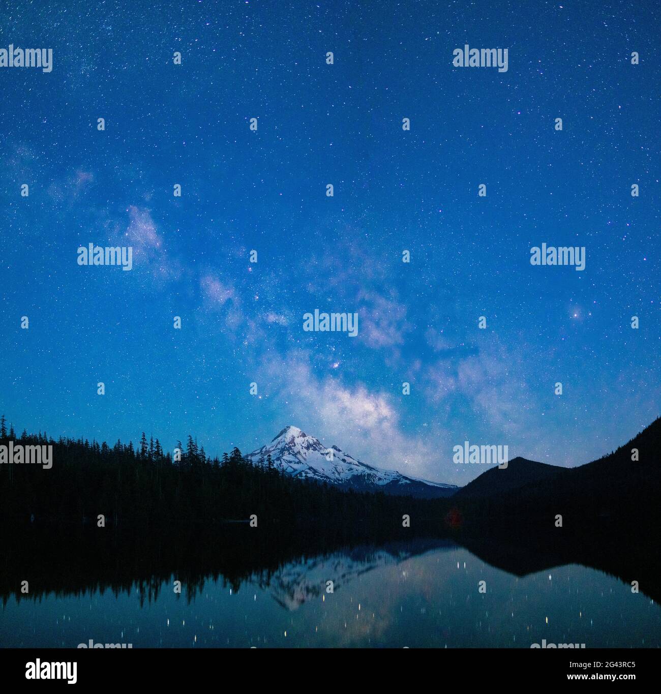 Milky Way and stars in sky at night above Mount Hood and Lost Lake, Oregon, USA Stock Photo