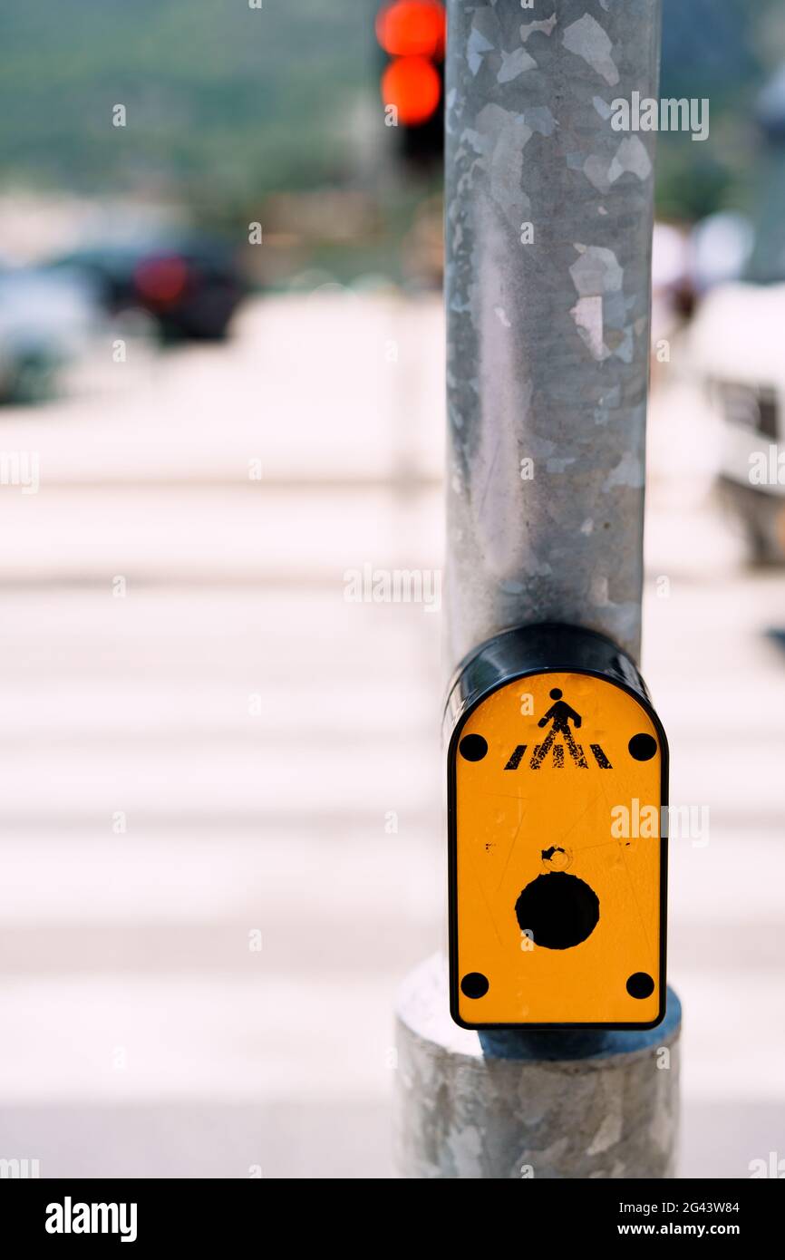 Traffic light switch button. Yellow button on traffic lights on the road with pedestrian crossing Stock Photo