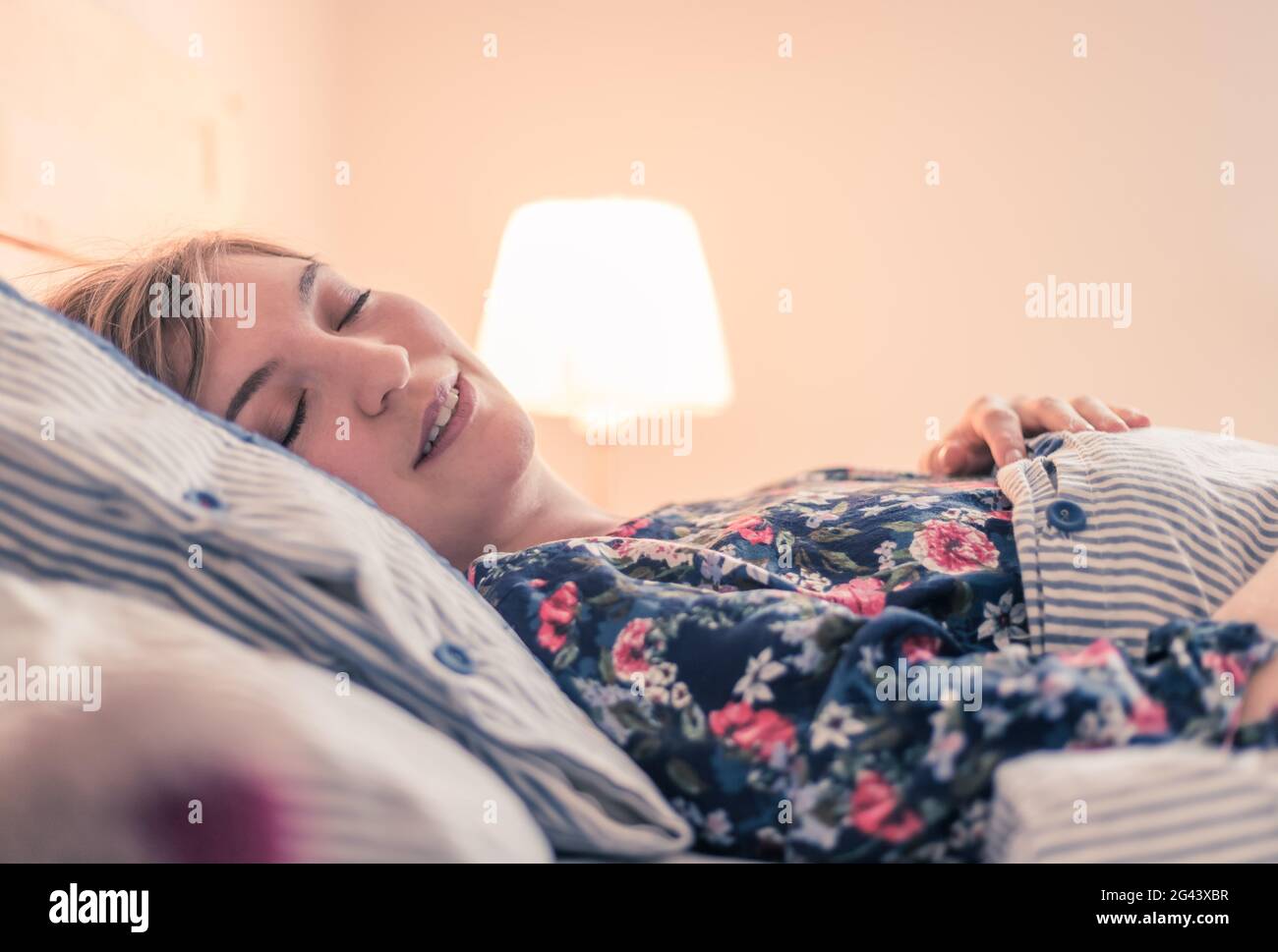 Restful sleep: Young female is sleeping in her bed, close up Stock Photo