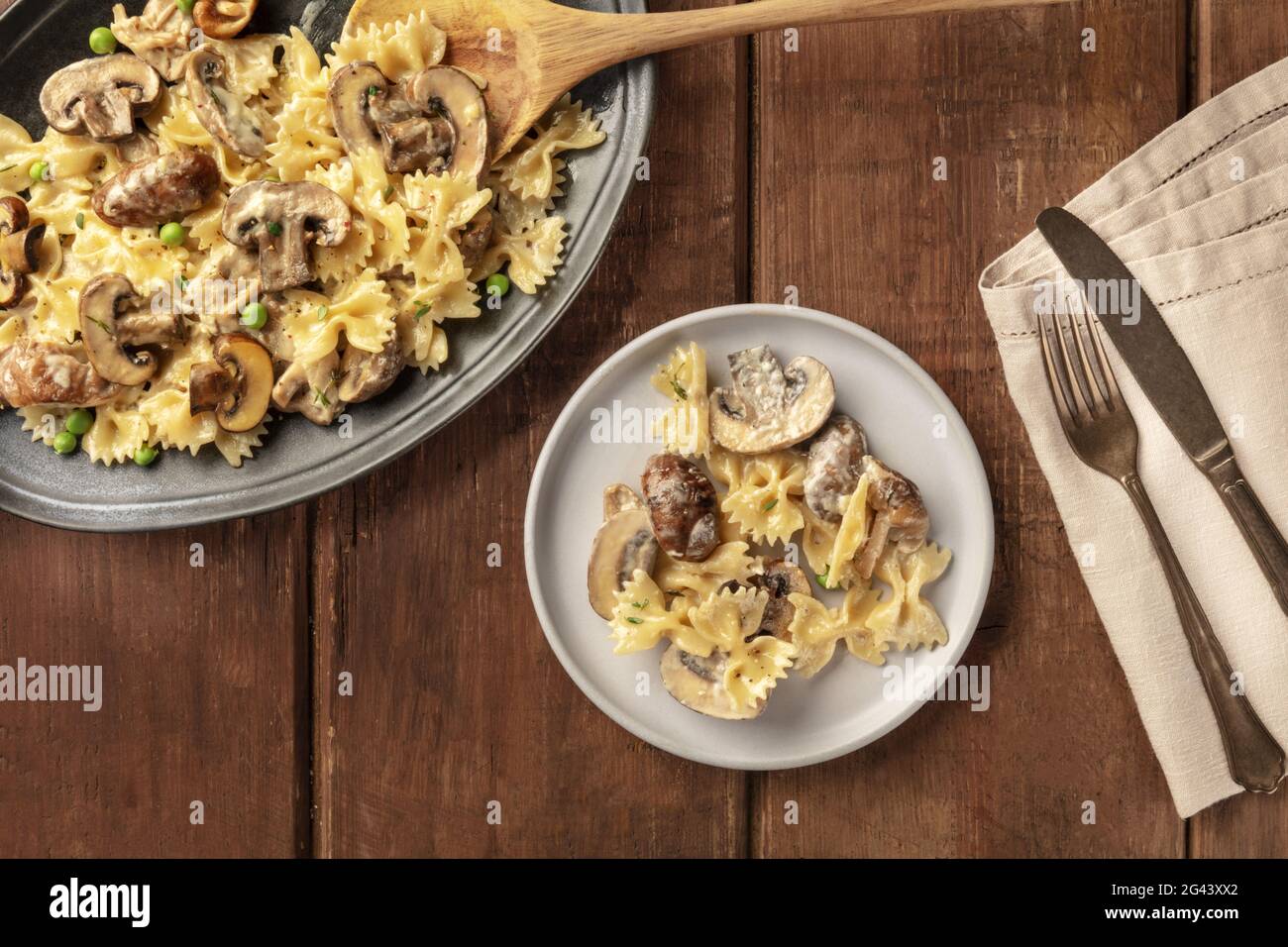 Mushroom and cheese pasta. Farfalle with cremini and green peas Stock