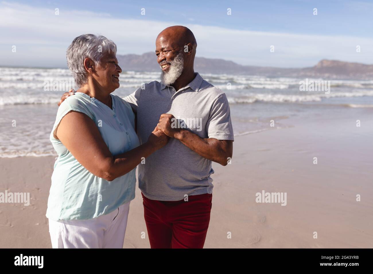 Happy senior african american couple embracing each other on the beach ...