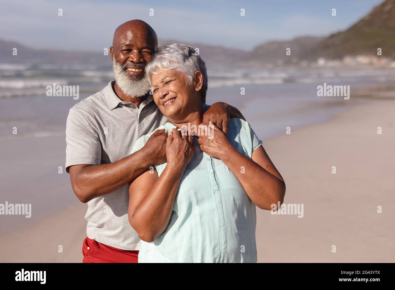 Happy senior african american couple embracing each other on the beach ...