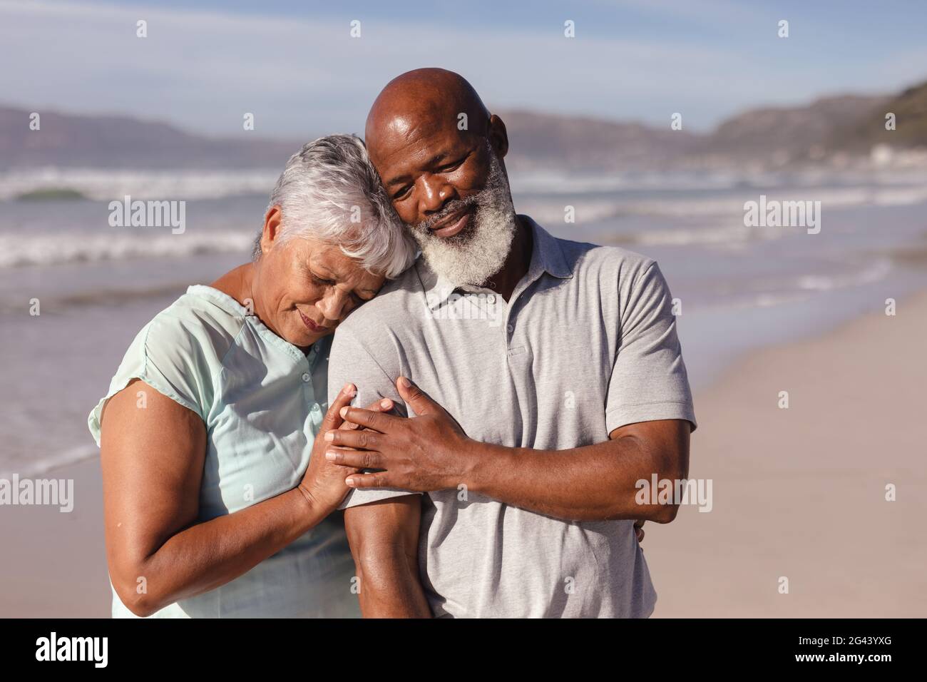 Happy senior african american couple embracing each other on the beach ...
