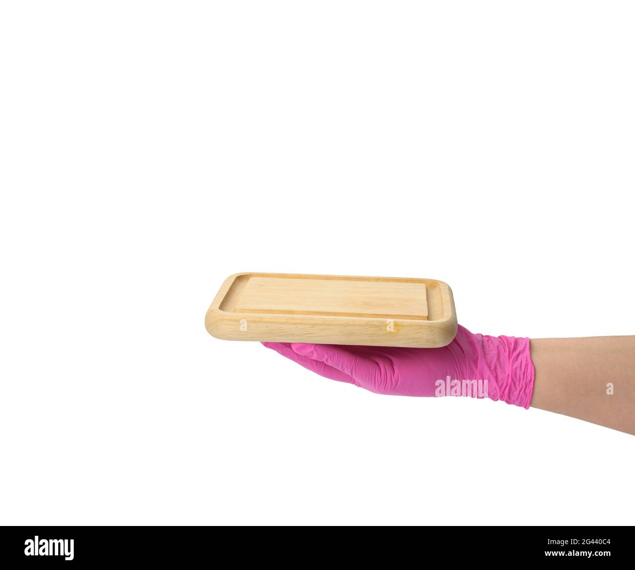 Hand in pink latex glove holding rectangular cutting board on white isolated background Stock Photo