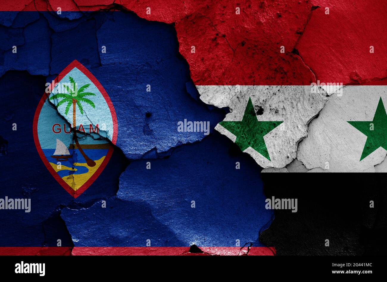 Flags of Guam and Syria painted on cracked wall Stock Photo