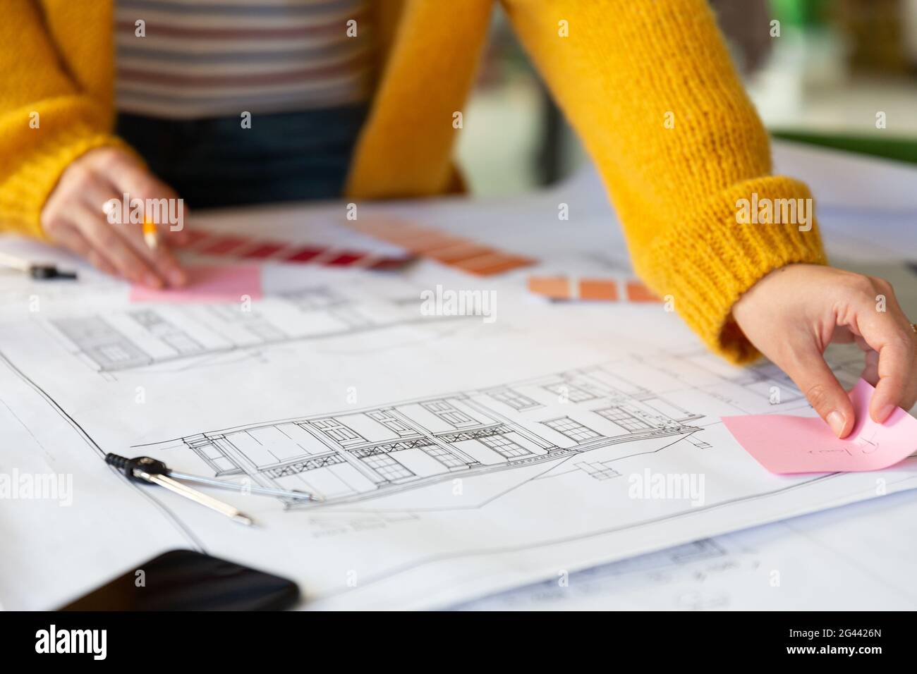 Midsection of caucasian businesswoman writing and placing memo notes on ...