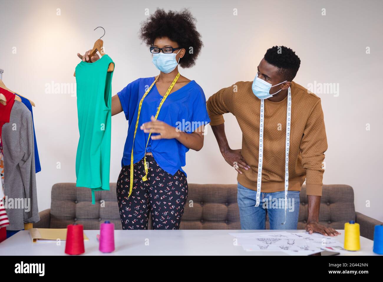 Diverse male and female fashion designers at work discussing and ...