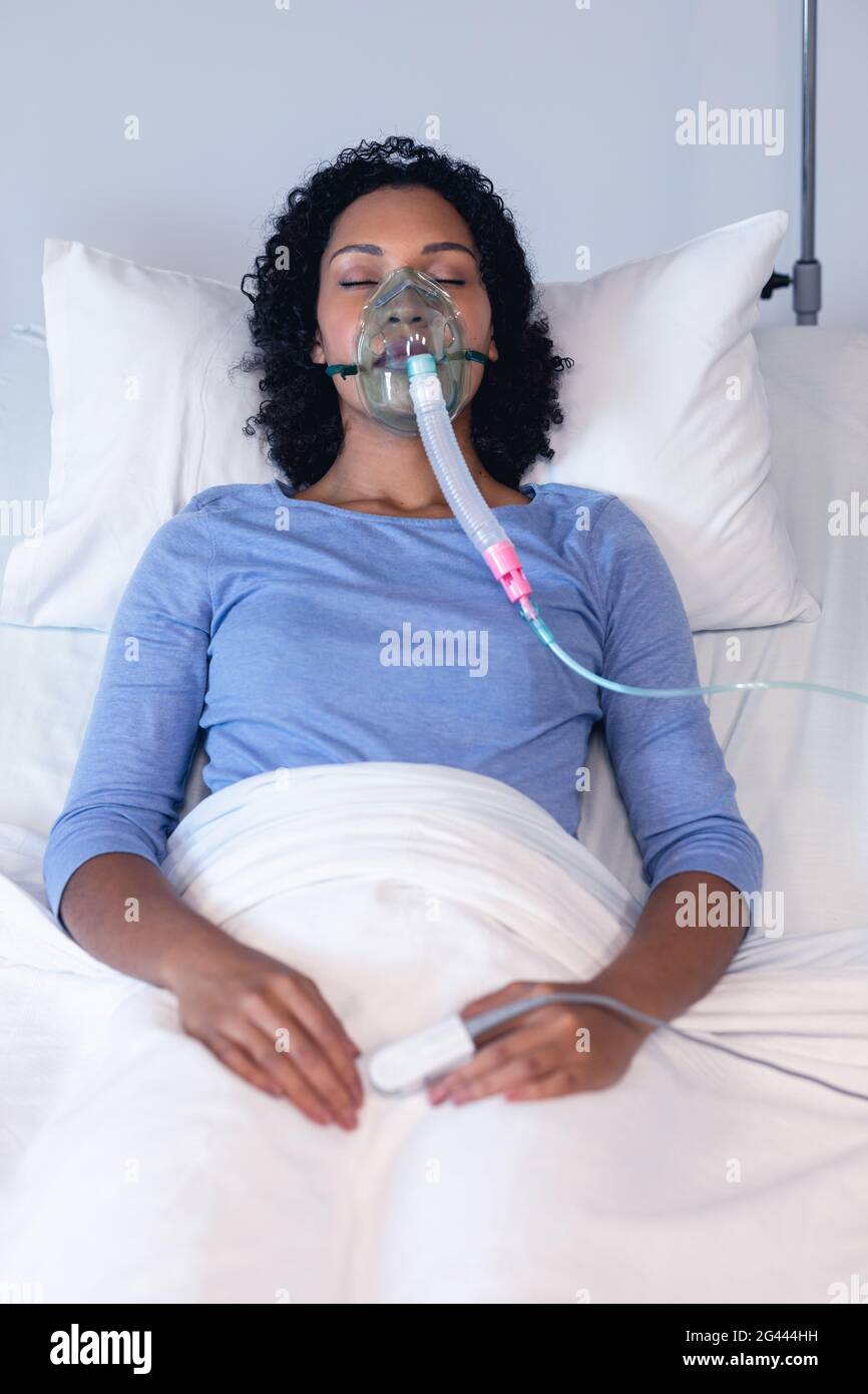 Sleeping african american female patient in hospital bed with oxygen ...