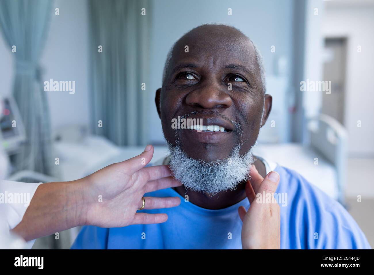 Caucasian female doctor palpating lymph nodes of african american male patient Stock Photo